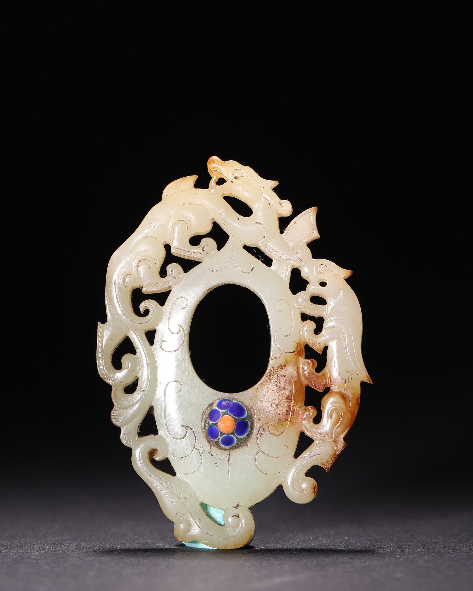 Openwork Hetian Jade Phoenix Dragon Heart Shaped Pendant With Inlaid Gem, Han Dynasty: Wt 28g (0.062 lb); L 7cm (2.76 in); W 5cm (1.97 in)Carved from Hetian jade with reddish brown patina. Heart shaped pendant, openwork dragon and phoenix, gem inlaid at center, cloud patterns incised on