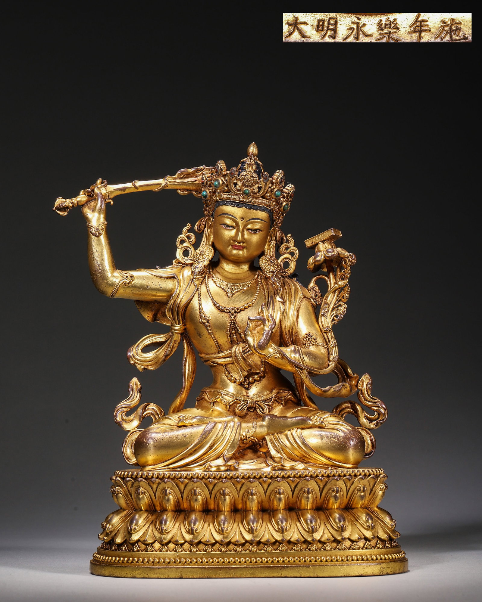 Gilt Bronze Seated Manjushri, Imperial Court Made, Marked "Made In Yongle Reign Of Great Ming",: Wt 1337g (2.95 lb),L 14cm (5.51 in),W 11cm (4.33 in),H 20cm (7.87 in)Imperial court made.Manjushri seated in padmasana with serene countenance, wearing gem set five leaf crown and adorned with necklac
