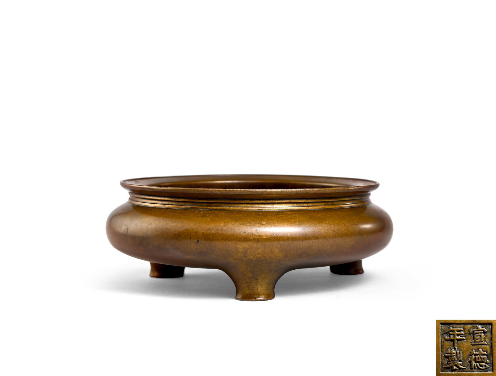 Bronze Tripod Censer, Ming Dynasty (1368 1644): D 12.5cm (4.92 in); H 4.5cm (1.77 in)Bronze tripod censer with circumferential bow string patterns. Bulbous body with three rounded feet. Four character Xuande mark on base. Smooth lustrous aged patin