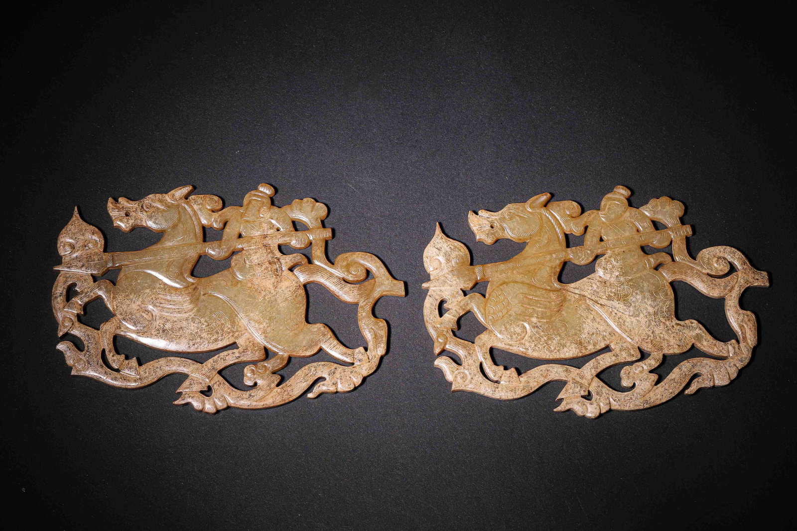 Pair Of Openwork Jade Plaques With Equestrian Figure, Han Dynasty (202 Bc 220 Ad): Wt 190g (0.42 lb); L 13.5cm (5.31 in); W 9cm (3.54 in)A pair of jade openwork plaques. Carved with figure riding mythical beast holding weapon, incised cloud patterns. Ancient patina covers surface, e
