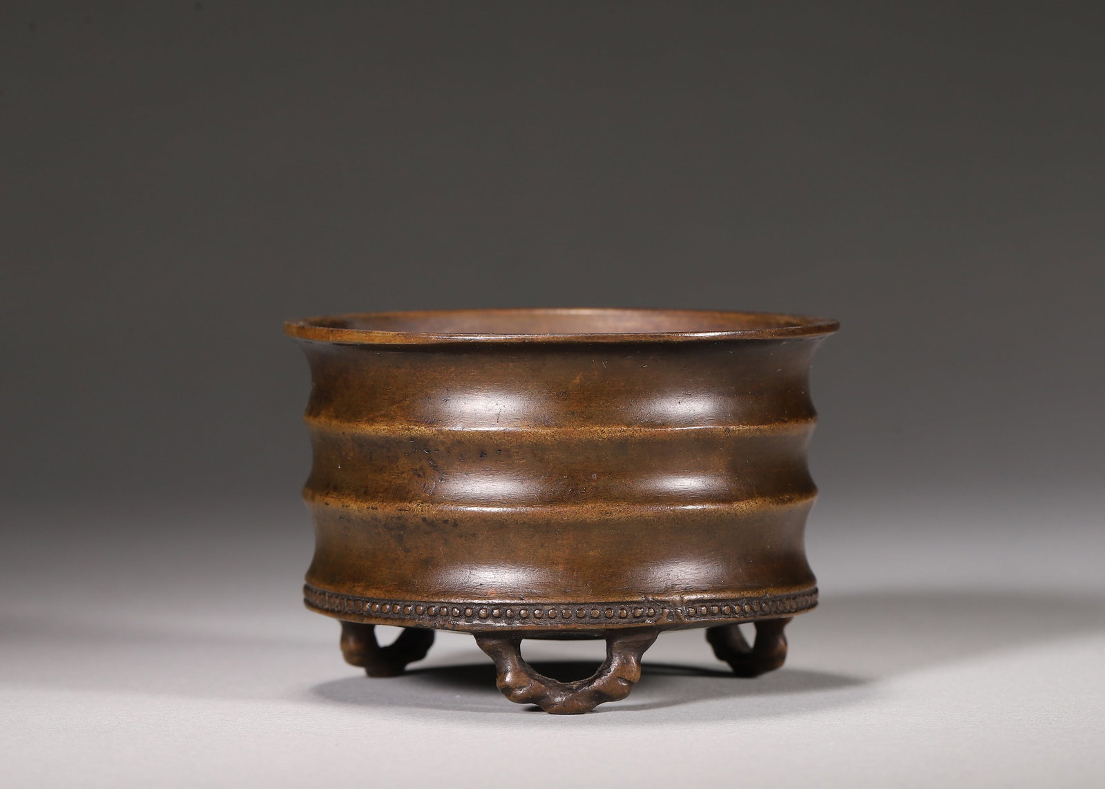 Bronze Bamboo Segment Censer, Daming Xuande Mark (Ming Dynasty,1368 1644): Wt 236g (0.52 lb),D 7cm (2.76 in),H 4.8cm (1.89 in)Bronze cylindrical censer moulded with bamboo segment ribs, flared rim, bead band above three bamboo form feet. Thick mellow patina, incense residue 