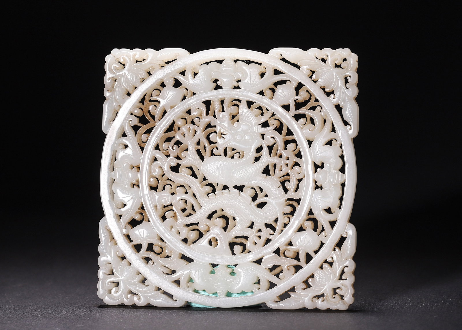 Hetian White Jade Openwork Square Plaque With Dragon And Floral Decoration, Ming Dynasty: Wt 111g (0.24 lb); L 9.4cm (3.701 in); W 9.4cm (3.701 in)Carved from Hetian white jade, this square plaque has multi layer openwork. A dragon lies in central round frame surrounded by scrolling flower