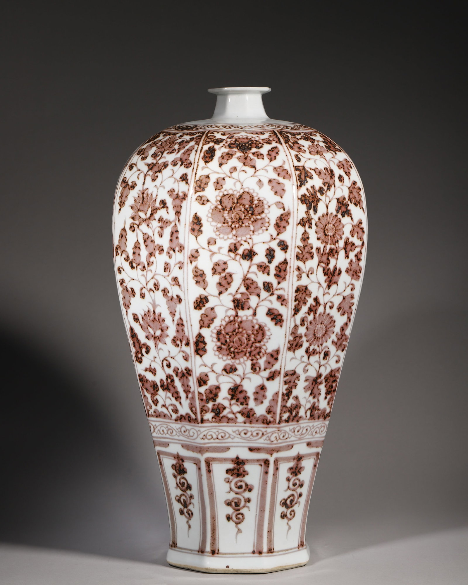 Underglazered Octagonal Meiping With Scrolling Floral Motifs, Hongwu Ming (13681398 Ce): W 24cm (9.45 in); H 47cm (18.504 in)Octagonal meiping painted in underglazered. Each facet is adorned with scrolling flowers. Lower body features stylized lotus petal panels. Unglazed base without mar