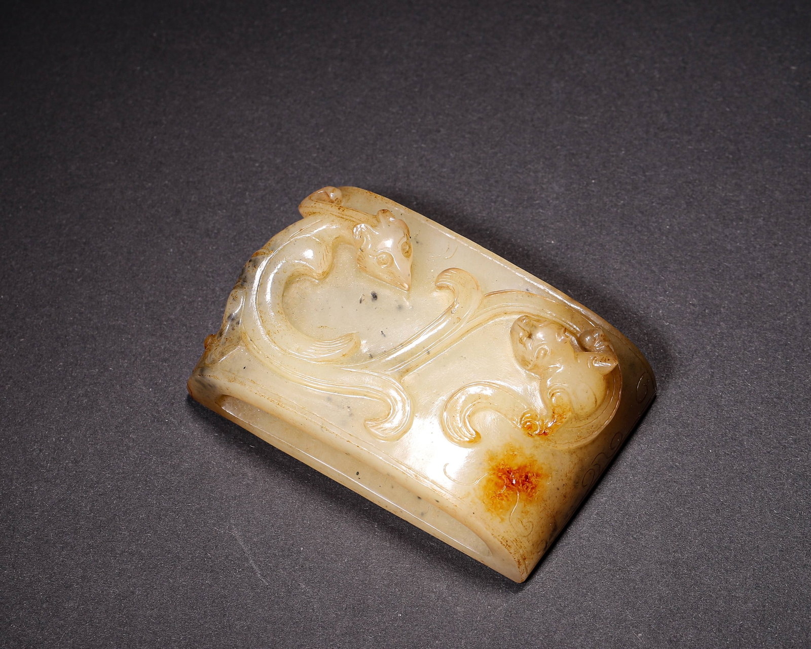 Hetian Jade Scabbard Slide With High Relief Double Chilong, Han Dynasty: Wt 76g (0.17 lb); L 6cm (2.36 in); W 3.8cm (1.496 in); H 2cm (0.79 in)Hetian jade scabbard slide with rectangular slot, high relief double chilong dragons. Side incised cloud patterns, partial yellowi