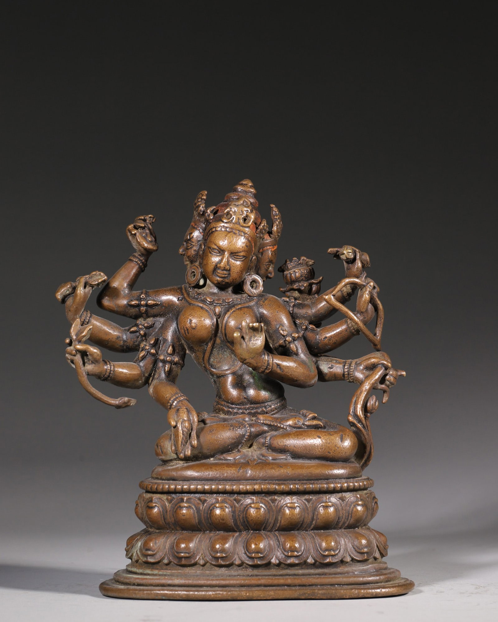 A Bronze Statue Of Usnisa Vijaya Dharani (Three Faces And Eight Arms), Qing Dynasty: H 20cm (7.87 in); L 15.5cm (6.1 in); W 10cm (3.94 in); Wt 2082g (4.59 lb)This is a Qing Dynasty bronze statue of Usnisa Vijaya Dharani (Three Faces and Eight Arms), an important deity in Tibetan Buddh