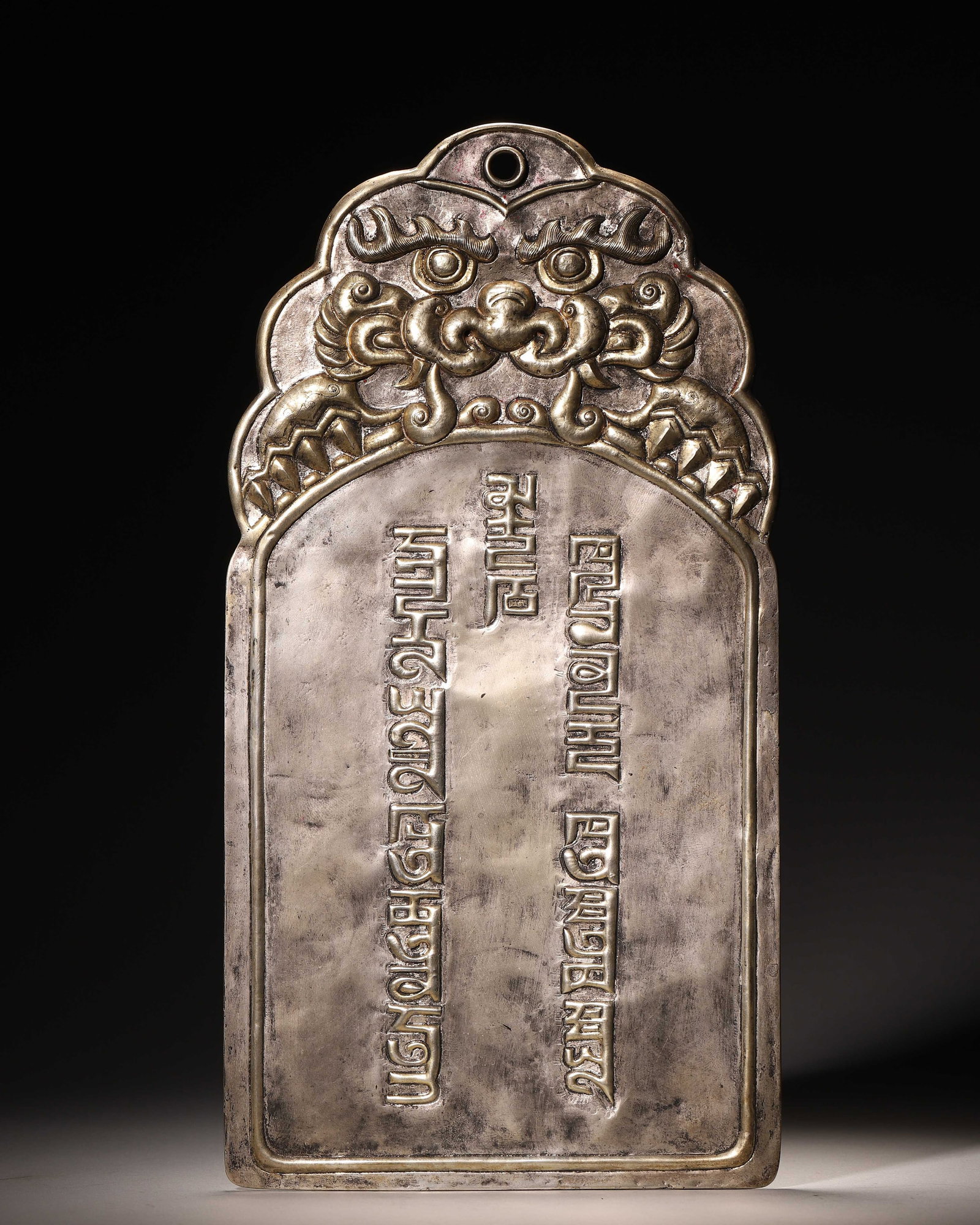 Bronze Plaque With Beast Head Relief And Phags Pa Script (Yuan Dynasty,1271 1368): Wt 534g (1.18 lb); L 16cm (6.299 in); H 31cm (12.205 in)Bronze plaque with pierced cloud shaped top, carved beast head and cast Phags pa script. Reverse is plain with wear marks and natural patina.