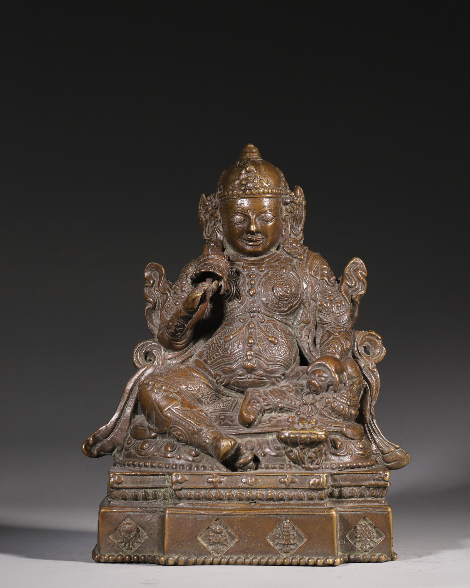 A Bronze Statue Of Jambhala, Qing Dynasty: H 24cm (9.45 in); L 20cm (7.87 in); W 14cm (5.51 in); Wt 4092g (9.02 lb)This is a Qing Dynasty bronze statue of Jambhala, the wealth deity in Tibetan Buddhism. Cast in fine bronze with mellow patina, 