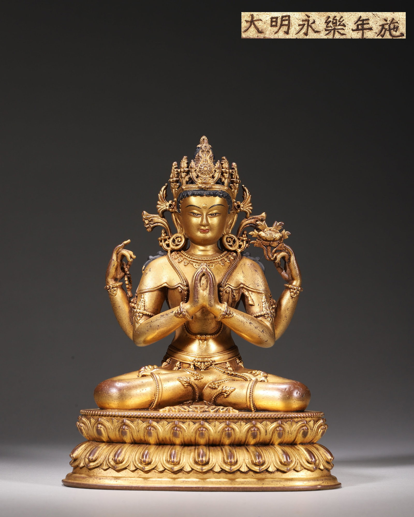 Gilt Bronze Seated Four Armed Avalokiteshvara, Imperial Court Made,Marked "Made In Yongle Reign Of: Wt 818g (1.803 lb),L 12cm (4.72 in),W 10cm (3.94 in),H 17cm (6.69 in)Imperial court made.The deity sits in padmasana with ornate crown. Primary hands pressed together at chest; upper right hand holds 