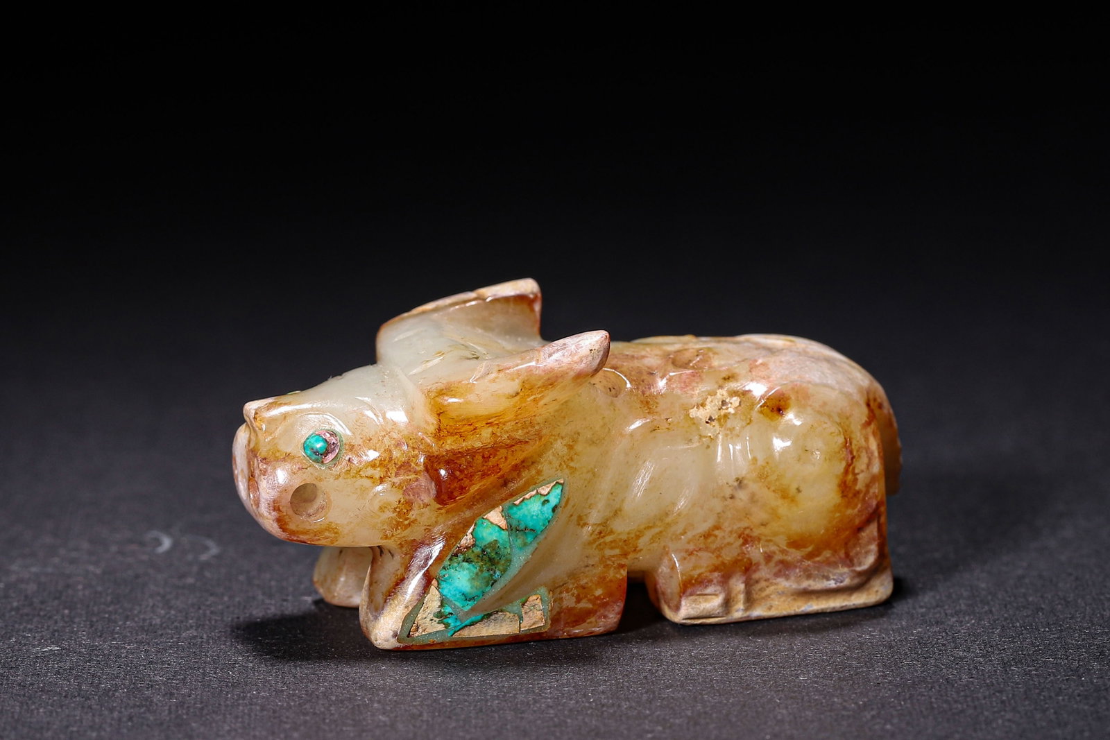 Jade Recumbent Ox Inlaid With Turquoise, Han Dynasty: Wt 57g (0.13 lb); L 5.6cm (2.205 in); W 2.5cm (0.98 in); H 2.5cm (0.98 in)Jade recumbent ox with widespread reddish brown patina. Turquoise inlaid on eyes and limbs, scroll patterns carved on body, pi