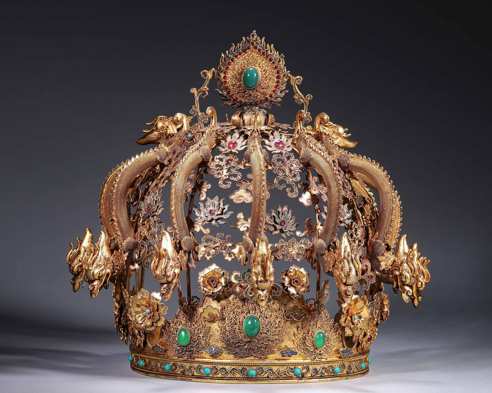 Gilt Copper Filigree Jewelled Nine Dragon Crown, Qing Dynasty (1644 1912): Wt 2000g (4.41 lb); L 32cm (12.598 in); W 23cm (9.055 in); H 30cm (11.81 in)Gilt copper filigree crown decorated with nine dragons, inlaid with turquoise and coloured gems. Flame shaped finial, cloiso