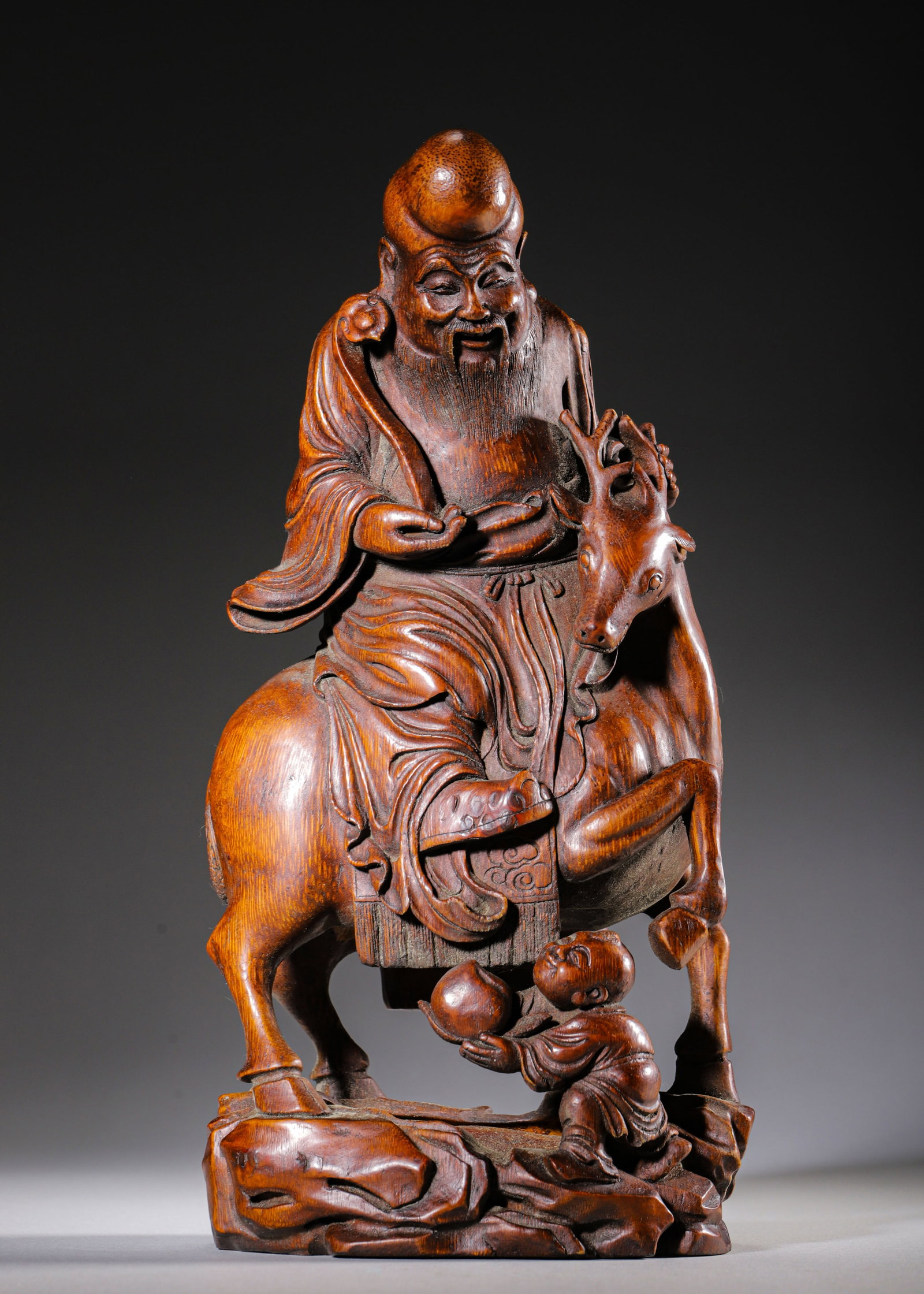 Carved Bamboo God Of Longevity Riding Deer With Boy Presenting Peach, Qing Dynasty (1644 1912 Ad): L 13cm (5.12 in); W 10cm (3.94 in); H 28cm (11.024 in); Wt 622g (1.37 lb)Carved integrally from bamboo root. The God of Longevity rides a sacred deer holding a ruyi sceptre with benevolent features; a