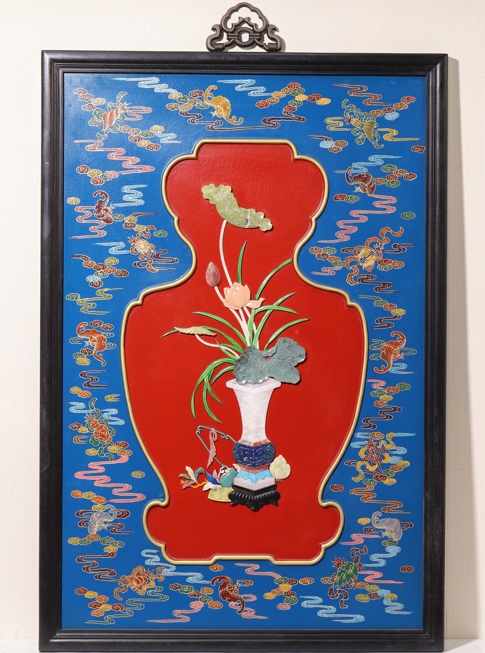 A Blue Lacquer Gold Painted Hundred Treasure Inlaid 'Lotus And Antiquities' Hanging Panel, Qing: W 70.0cm (27.56 in); H 103.0cm (40.55 in)A Qing Dynasty blue lacquer hanging panel with gold painted clouds and eight treasures. Features a central red lacquer panel with hundred treasure inlay depict