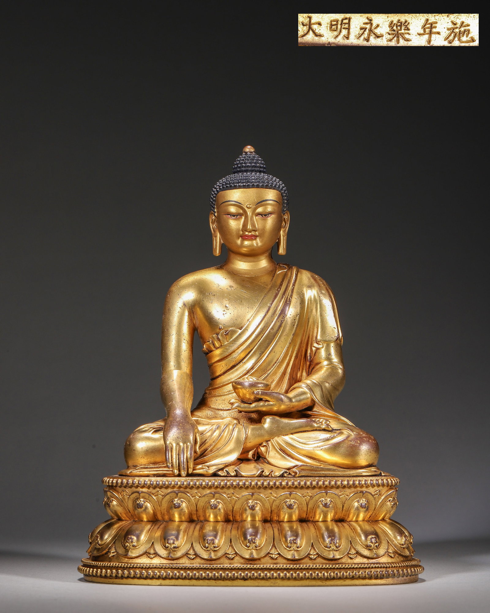 Gilt Bronze Seated Shakyamuni Buddha, Imperial Court Made, Inscribed "Made In Yongle Reign Of Great: Wt 1462g (3.22 lb),L 16cm (6.299 in),W 11cm (4.33 in),H 21cm (8.27 in)Imperial court made.The Buddha sits in full lotus posture upon a double tiered lotus throne. He possesses a mild, rounded visage, 