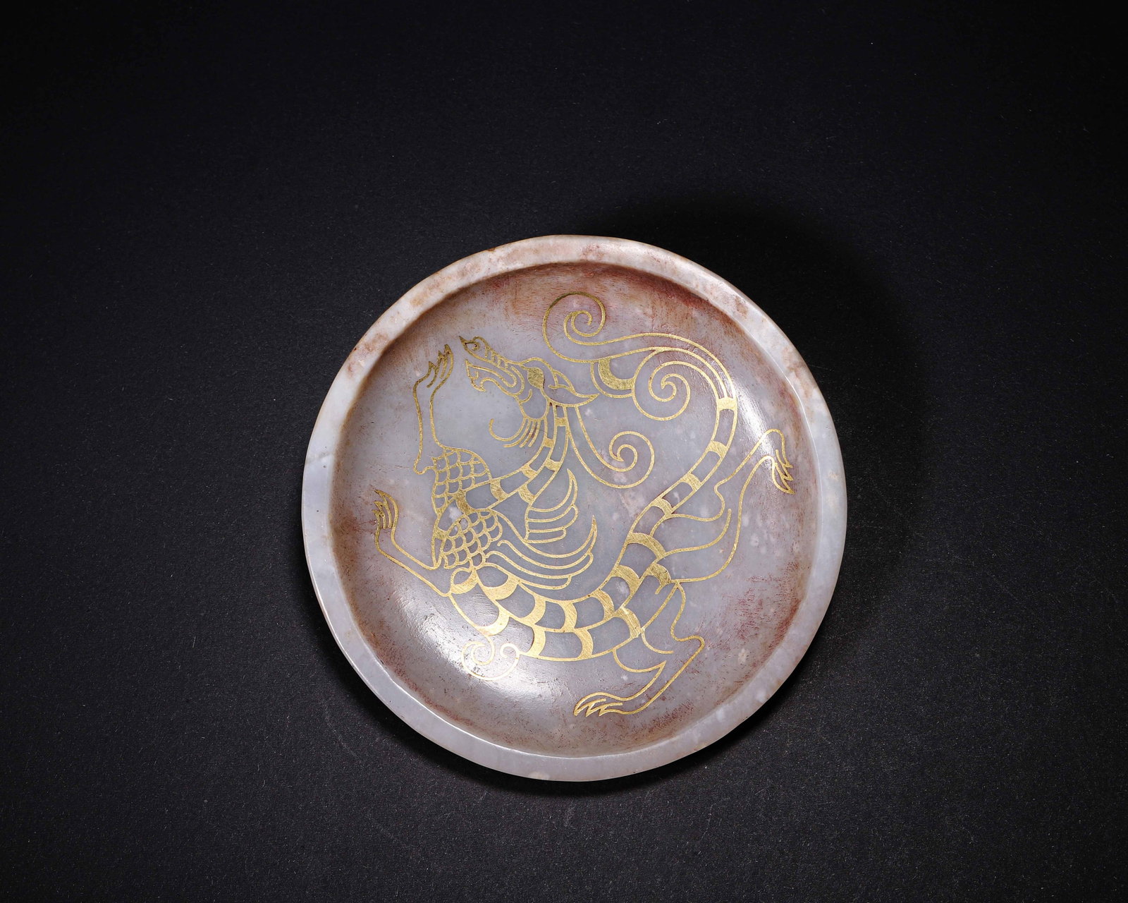 Han Dynasty, White Jade Dish With Gold-Inlaid Winged-Dragon Motif: Han-dynasty shallow circular jade dish with gently raised rim and thin walls. Interior decorated with fine gold-inlaid winged-dragon in dynamic scroll composition. The reverse bears gold-inlaid seal-s