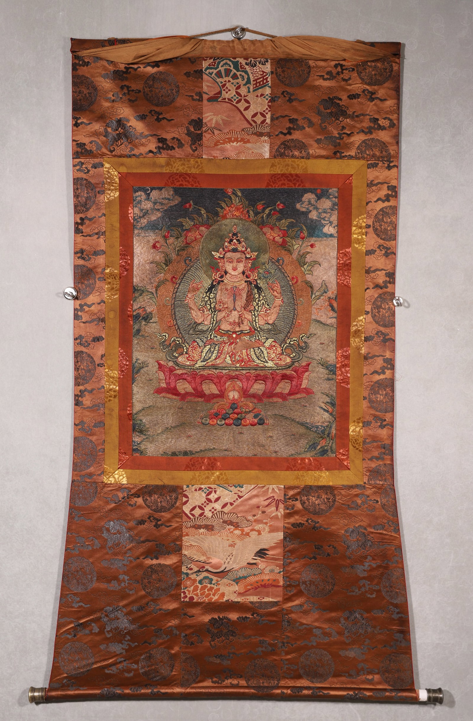 An Embroidered Thangka Of Four-Armed Avalokiteshvara, Qing Dynasty: A Qing Dynasty embroidered thangka of Four-Armed Avalokiteshvara, the Bodhisattva of Compassion. Meticulously crafted with fine embroidery and gold threads, depicting the seated deity with four arms, 
