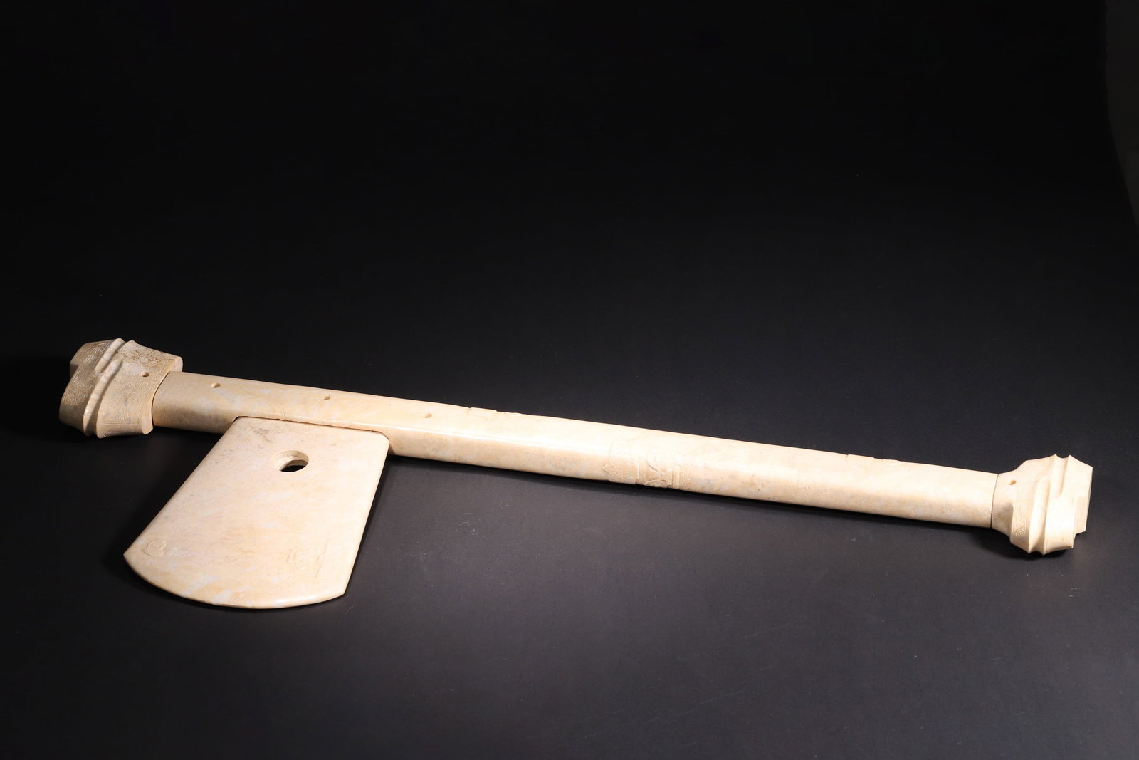 Liangzhu Culture Chicken Bone White Jade Yue: This Liangzhu Culture chicken bone white jade yue, composed of blade, handle and finial, features typical god-beast patterns. It embodies the ritual and political significance of Liangzhu jadeware, wi