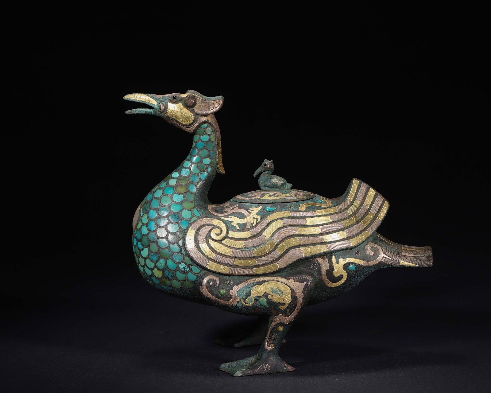 Warring States Period Bronze He-Vessel, Gold-Silver Inlaid With Turquoise, Divine Bird Form: Bronze he-vessel modelled as divine bird, spout at beak, bird-form knob on lid. Elaborate gold-silver inlay and turquoise inlay, decorated with auspicious beasts, gold-inlaid inscription on base.L23cm