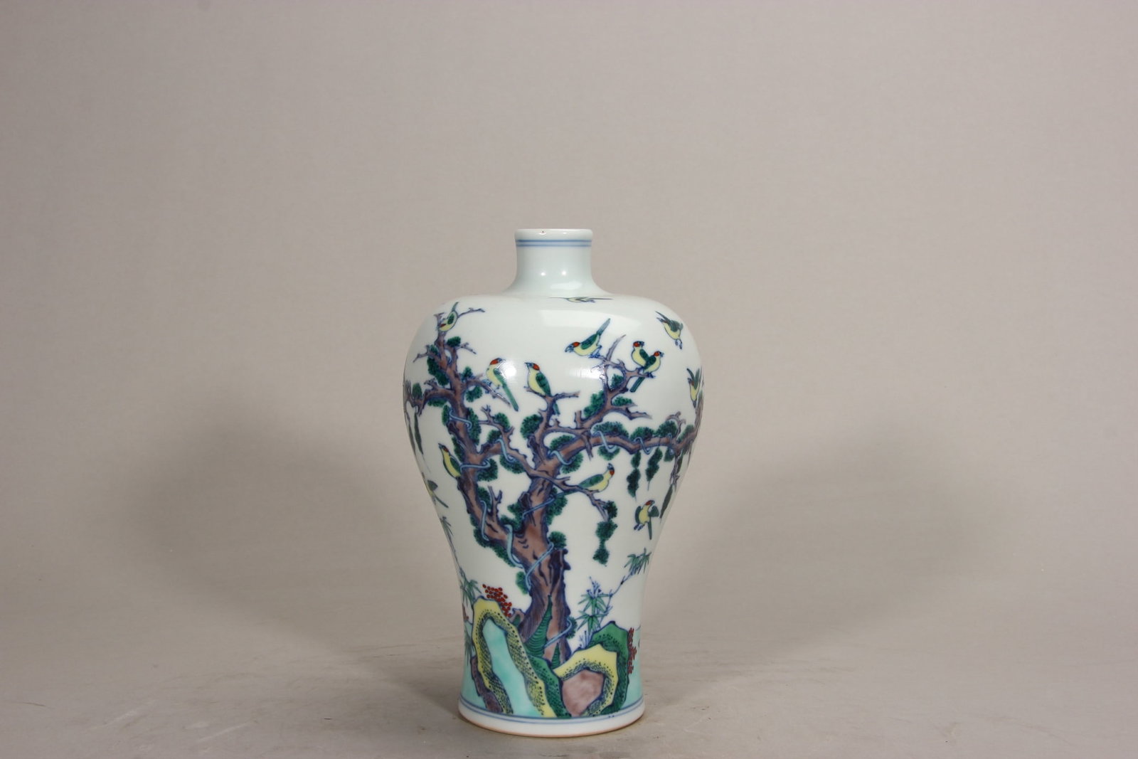 Kangxi-Period Doucai Plum Vase With Hundred-Bird Motif: Classic meiping form with small mouth, broad shoulder and tapering body. Doucai painted with numerous birds perching on pine branches or flying amid bamboo, rocks and clouds. Blue double-ring mark "Da