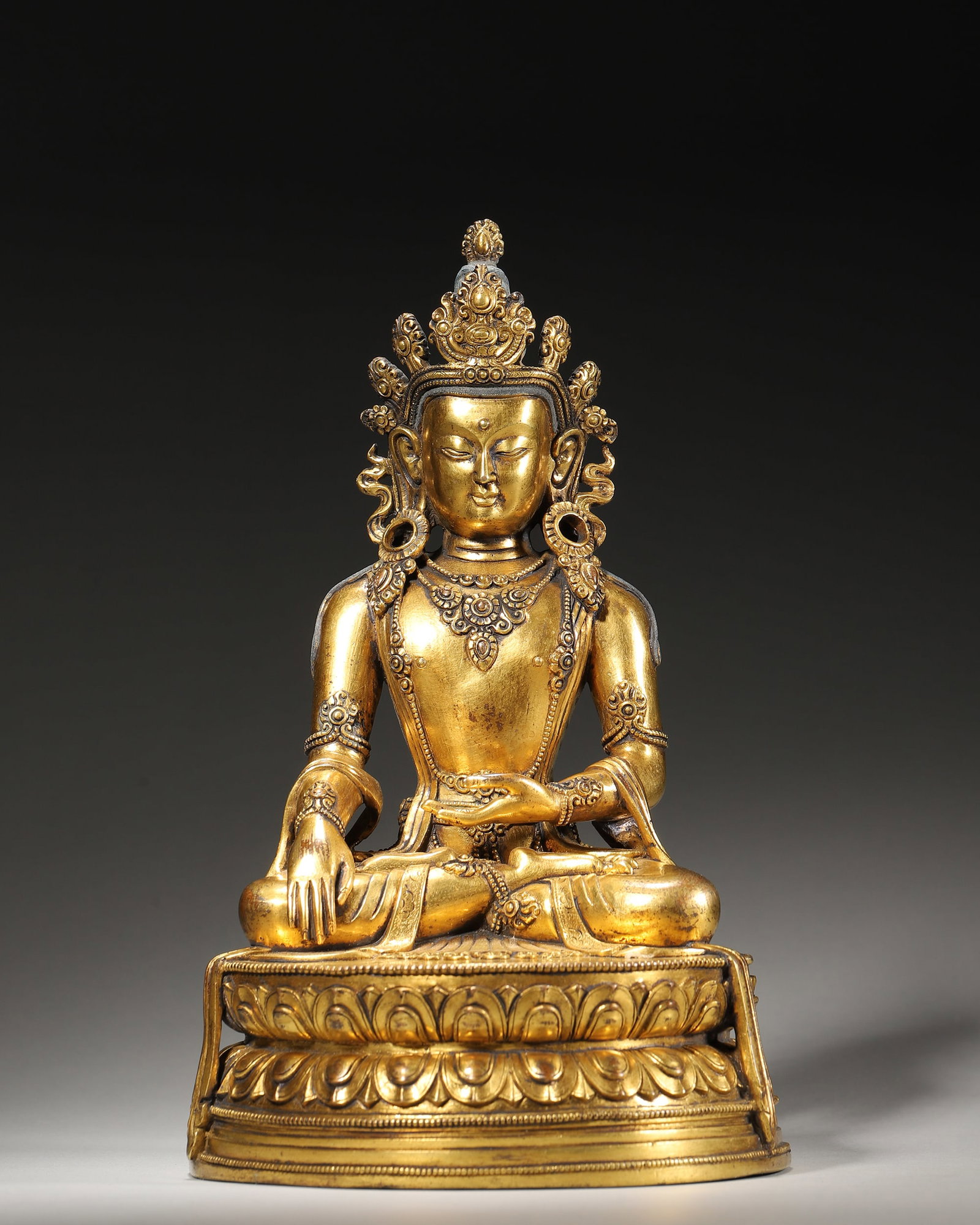 Qing Dynasty, Gilt-Bronze Crowned Shakyamuni Buddha Seated Figure: Gilt-bronze crowned Shakyamuni Buddha in full lotus posture. Adorned with jeweled ornaments, bhumisparsha mudra, left hand holds bowl. Double lotus base engraved with double vajra, fine Tibetan Buddhi