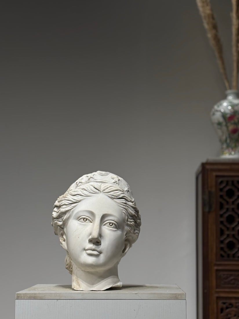 A Stone Fragmentary Head Of Diana The Moon Goddess, Ancient Roman Period: Ancient Roman stone carving of Diana, Goddess of the Moon. Diadem carved with moon and star relief motifs, layered flowing wavy hair tied at nape. Elegant soft facial contour, elongated eyes, straight
