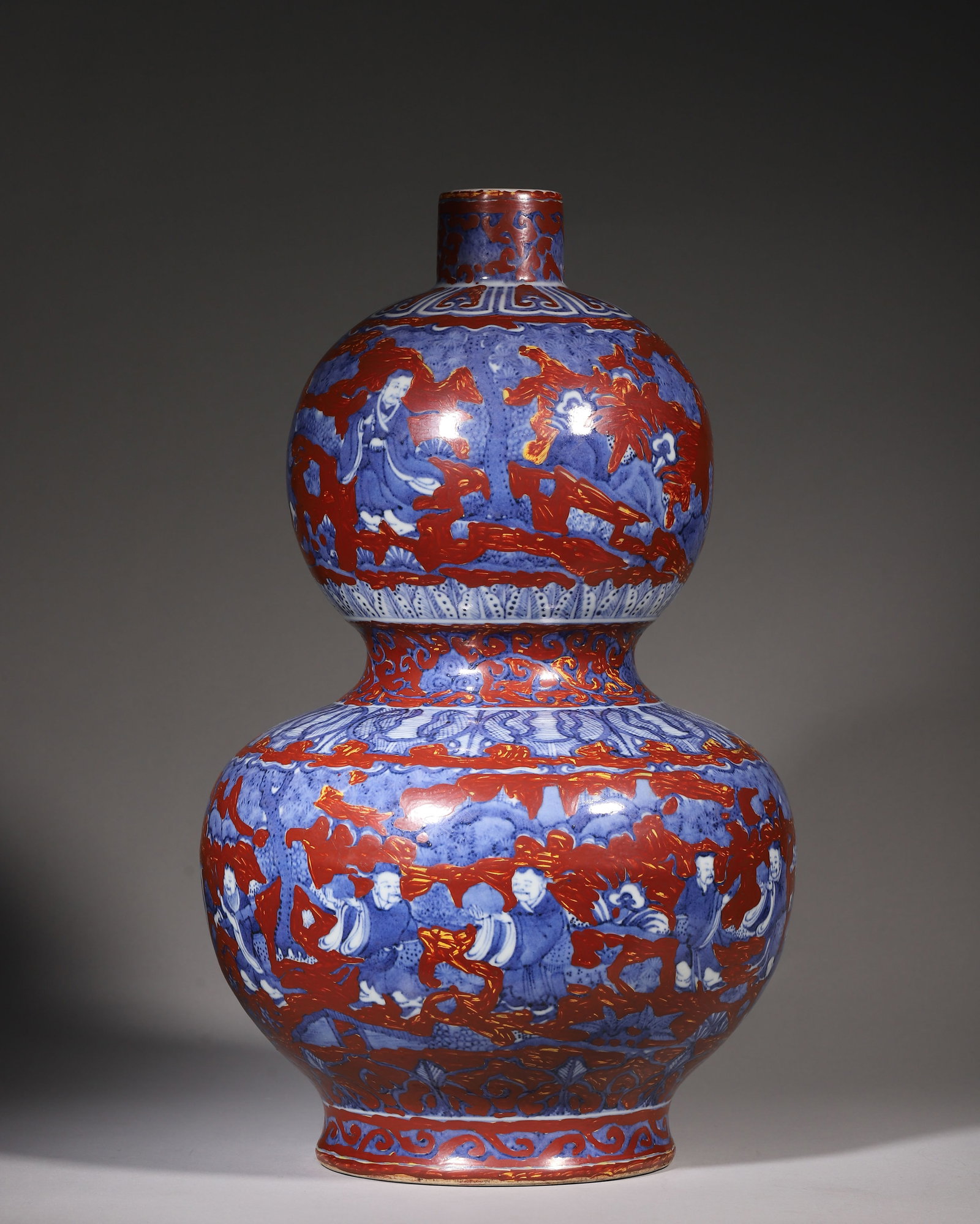 Blue And White Gourd Vase With Ironred Gilt Figural Decoration, Jiajing Period Ming Dynasty: Double gourd form vase with small mouth and recessed waist. Base bears six character Jiajing mark. Blueandwhite ground with ironred and gilt decoration depicting immortals, rich and vibrant colour sch