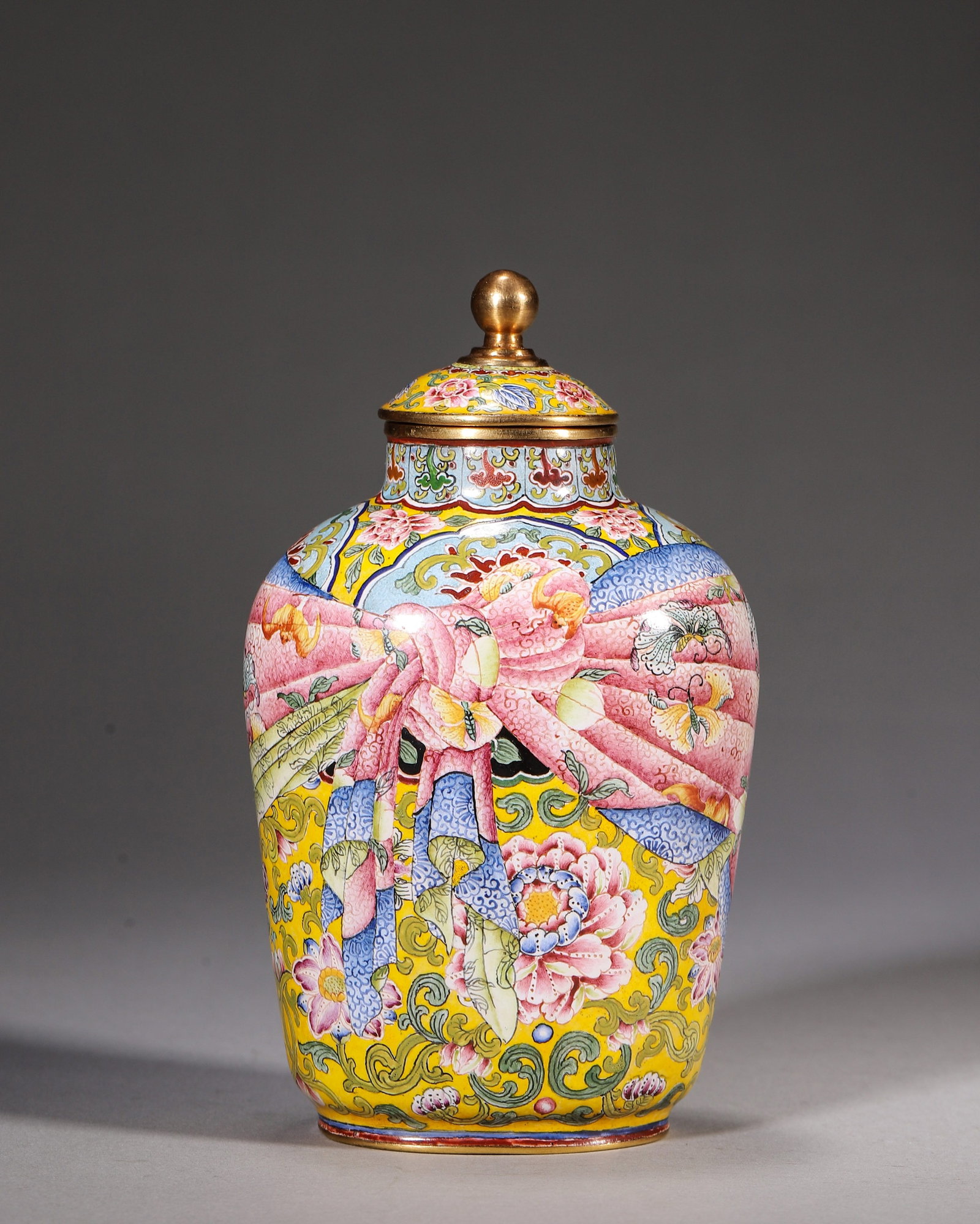 Bronze-Bodied Painted Enamel Lidded Jar With Yellow-Ground Ribbon-Wrapped Motif, Yongzheng Period,: Gilt-bronze jar on bright yellow ground decorated with scrolling flowers. Brocade-style ribbon motif painted with bats, peaches and butterflies symbolizing fortune and longevity. Gilt lid with ball-sh
