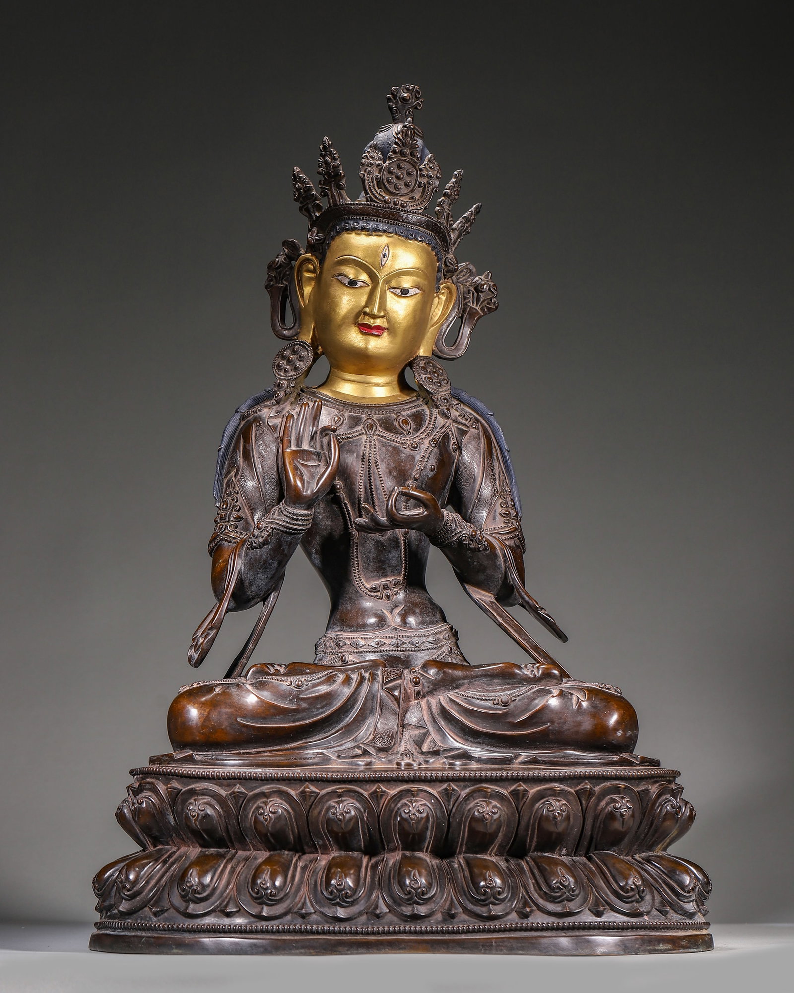 Qing Dynasty, Partially Gilt Bronze Seated Amoghasiddhi Buddha: As one of the Five Dhyani Buddhas in Tibetan Buddhism, this partially gilt bronze statue wears bodhisattva ornaments, seated in lotus position on double lotus base. It is for shrine worship and tantri