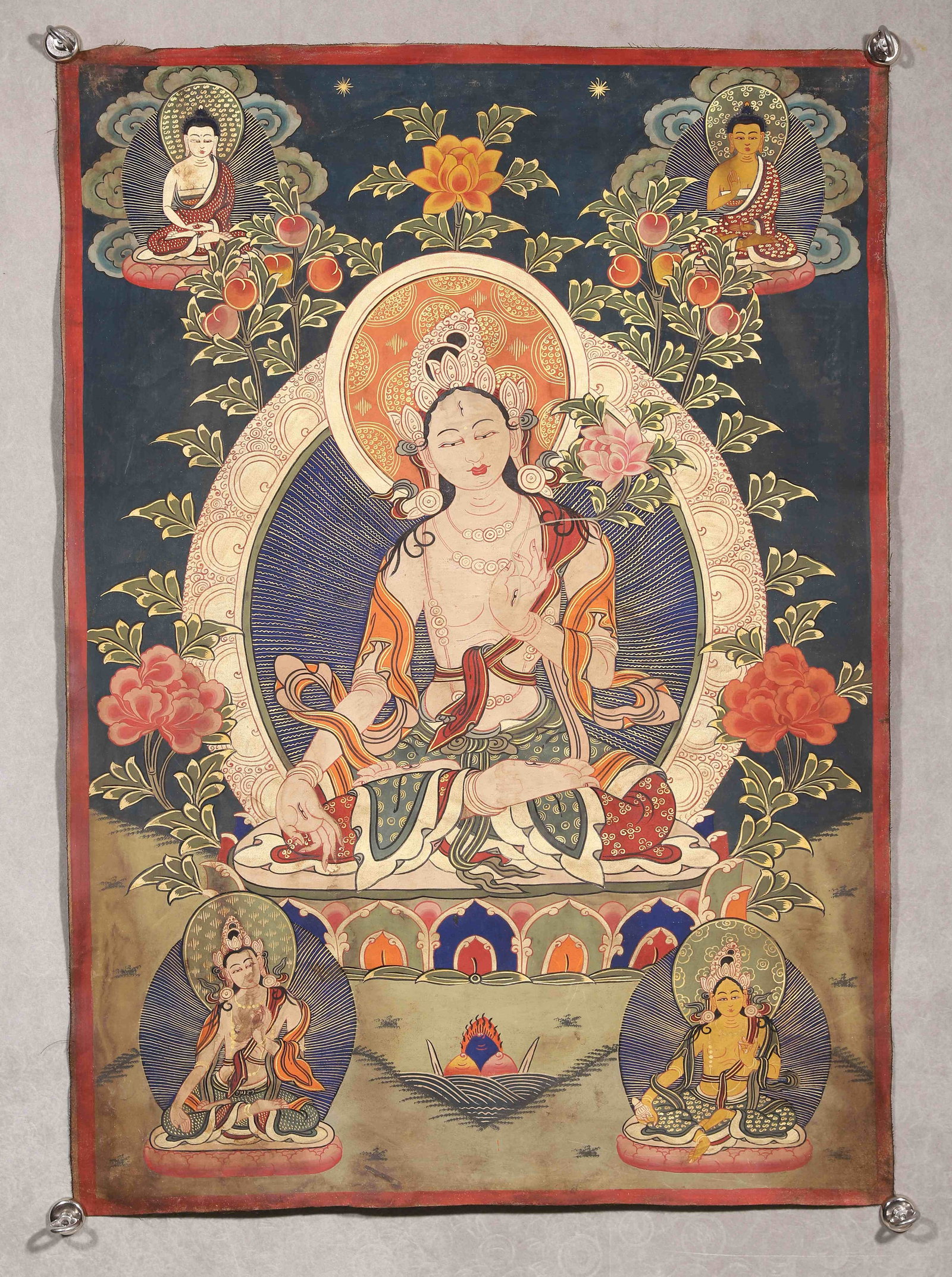 Qing Dynasty, Thangka Of White Tara: Qing-dynasty mineral-pigment painted thangka. White Tara sits in relaxed posture upon lotus throne with third eye on forehead, right hand in abhaya mudra, left hand holding lotus stem. Two buddhas dep