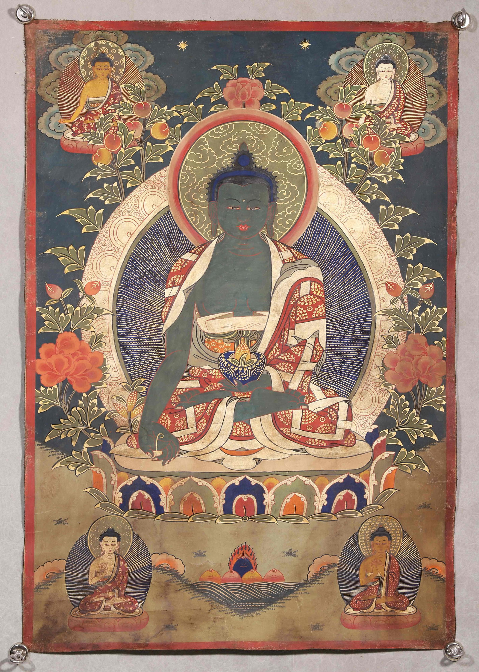 Qing Dynasty, Thangka Of Bhaisajyaguru: Qing-dynasty mineral-pigment painted thangka. Blue-green Bhaisajyaguru sits in full lotus posture on lotus throne, holding medicinal sprig and bowl. Surrounded by buddha figures amid clouds and flower