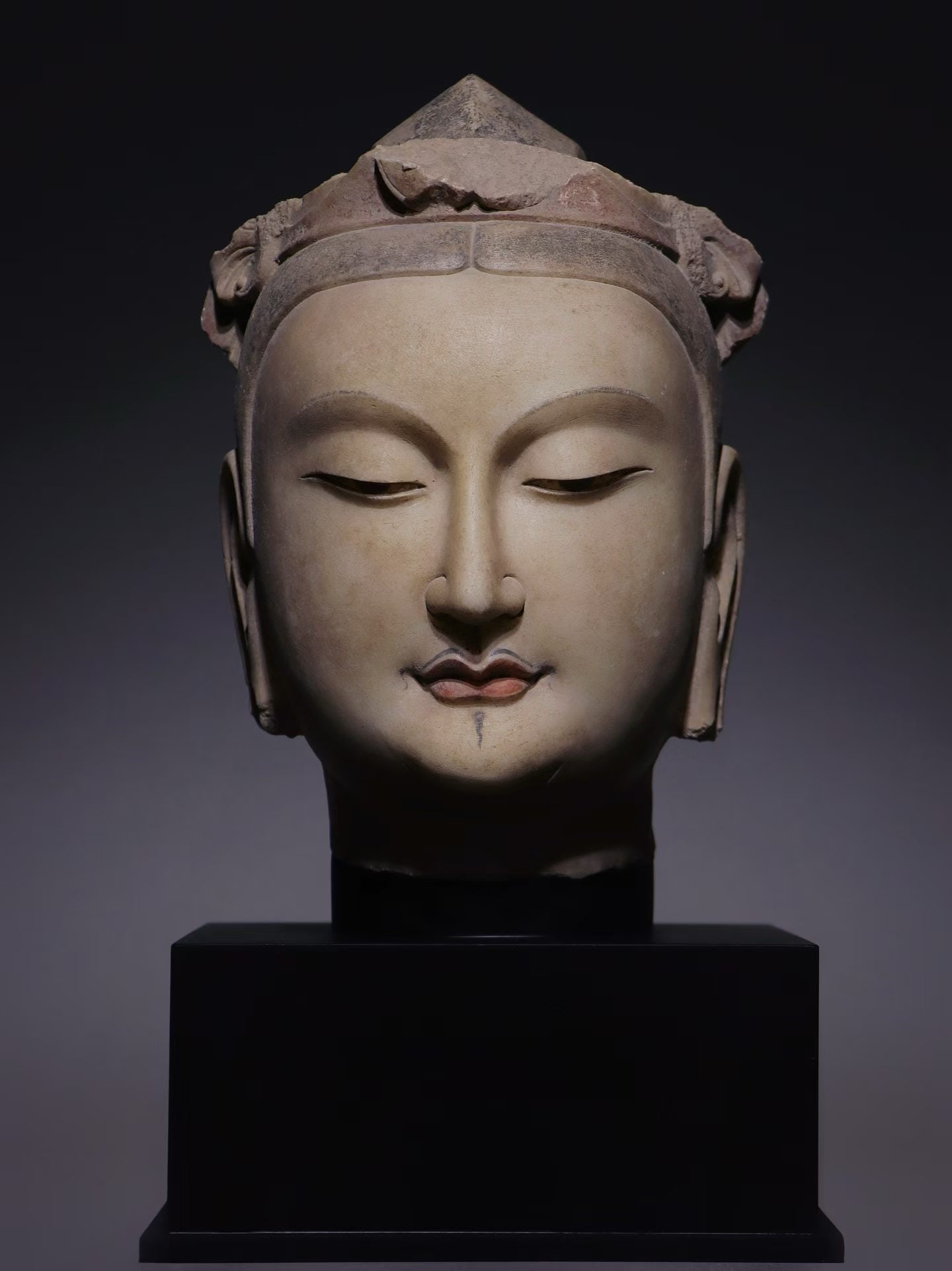 Northern Qi Dynasty, White Marble Bodhisattva Head: White marble stone carving for Buddhist worship. The bodhisattva has serene face with half-closed eyes, partial polychrome remains. Part of the crown is damaged, stone shows weathering traces.H30cm (1