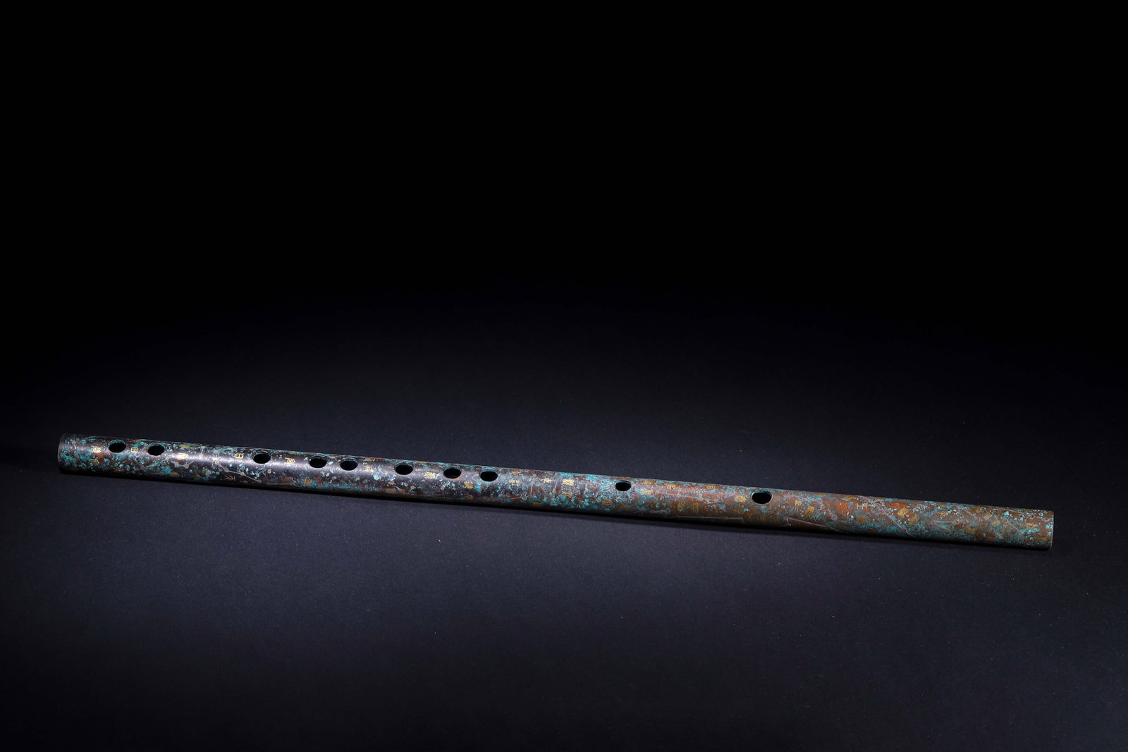 Han Dynasty,Bronze Flute With Gold-Inlaid Constellation Pattern: This ancient musical flute is cast in bronze with regularly arranged sound holes and well-proportioned form. Its surface is decorated with gold-inlaid constellation lines and archaic inscriptions in