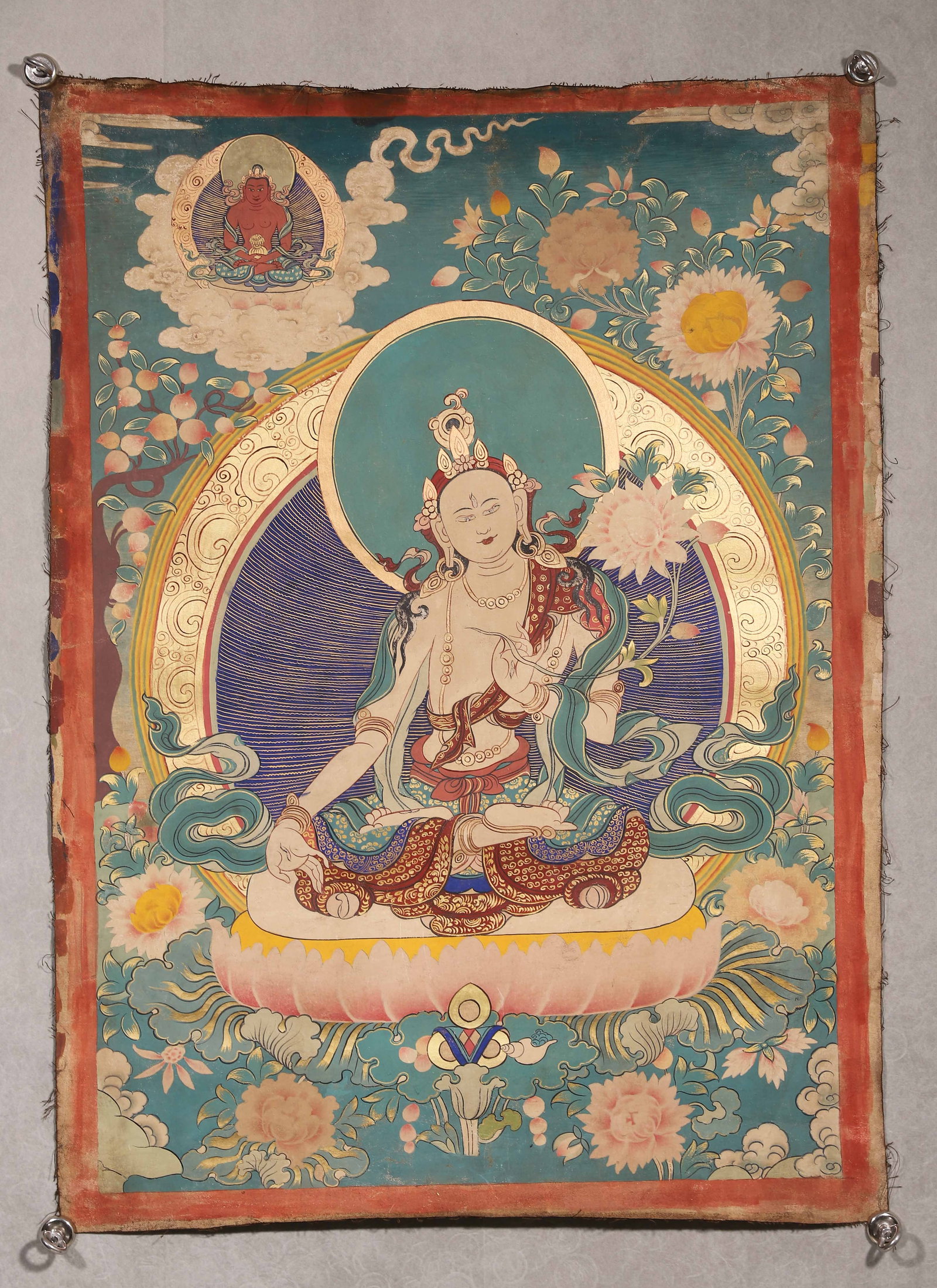 Qing Dynasty, Thangka Of White Tara: Qing-dynasty painted thangka. White Tara with pale complexion and third eye sits in full lotus position upon lotus throne, right hand in varada mudra, left hand holding utpala flower. Amitayus depicte