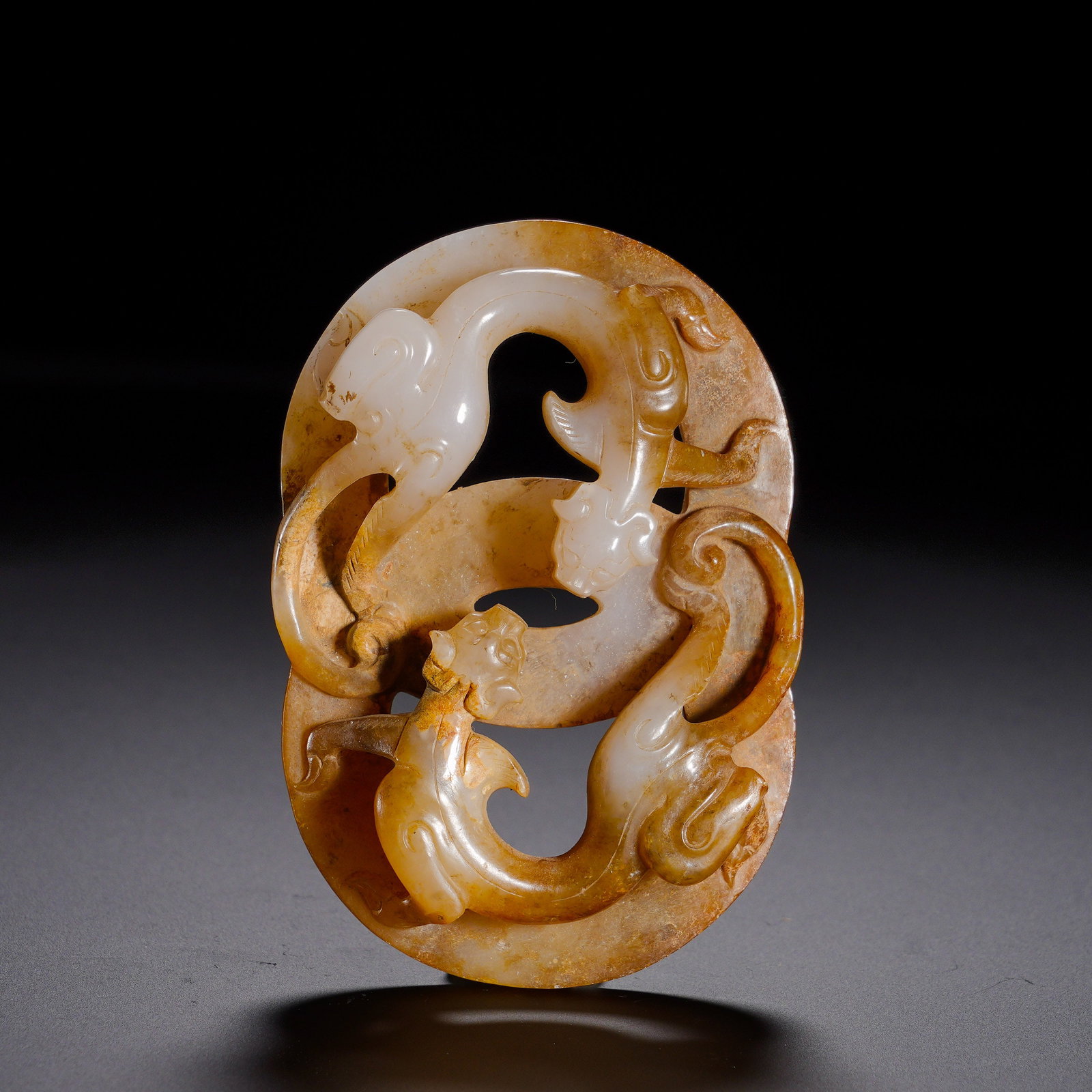 A Jade Pendant With A Double Chi Pattern Carved Through From Hetian, Han Dynasty: Height:5.2cm(2.05in), Width:7.5cm(2.95in), Weight:70g(0.154lb)Carved from Hetian jade, this pendant is covered by layered yellow-brown ancient patina with thick antique surface. Shaped as an oval bi-d