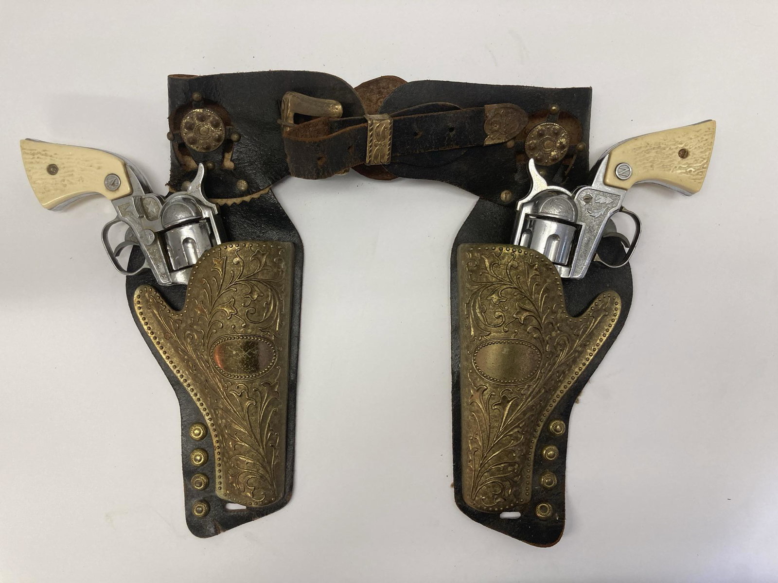Holsters with two stallion 38 cap gun pistols: Dual leather gun holsters with two metal/plastic Stallion 38 cap pistols inside.