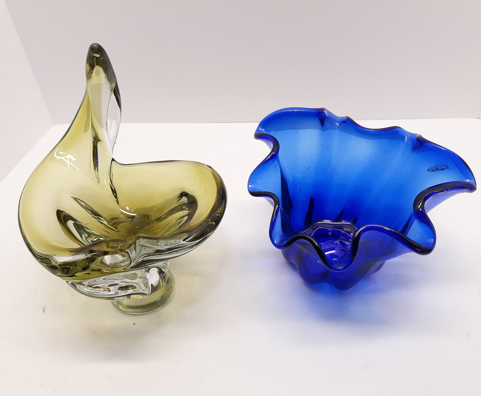 MCM Chalet Art Glass Piece & Art Glass Fluted Bowl: MCM Chalet Art Glass green & clear 7" x 8" x 9", minor chips on base. Cobalt blue fluted Art Glass bowl 8" x 8" x 5". Bubble on the bottom interior has some damage.