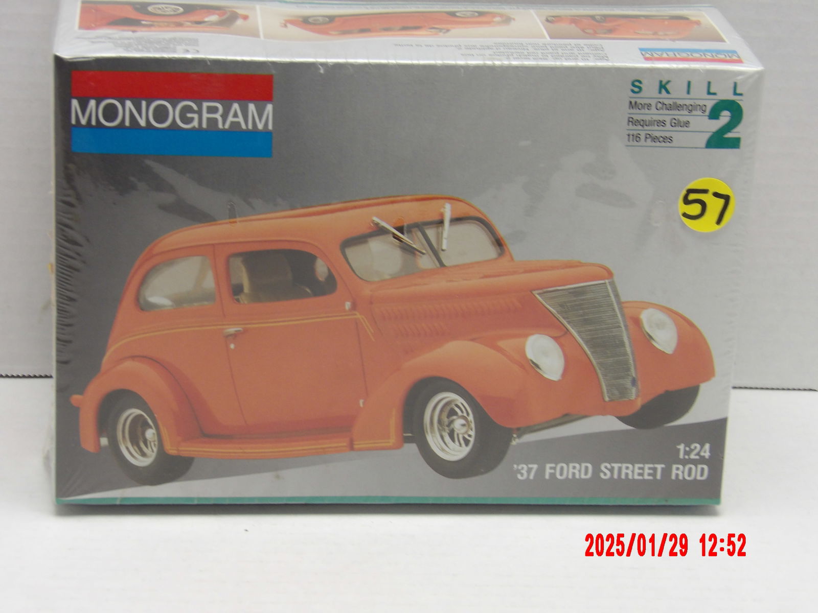 Monogram 1:24 Scale '37 Ford Street Rod Model Kit: Monogram brand model kit of a 1937 Ford Street Rod in 1:24 scale. The packaging prominently displays an orange hot rod with a sleek, customized design, including a classic grilled front, rounded fende