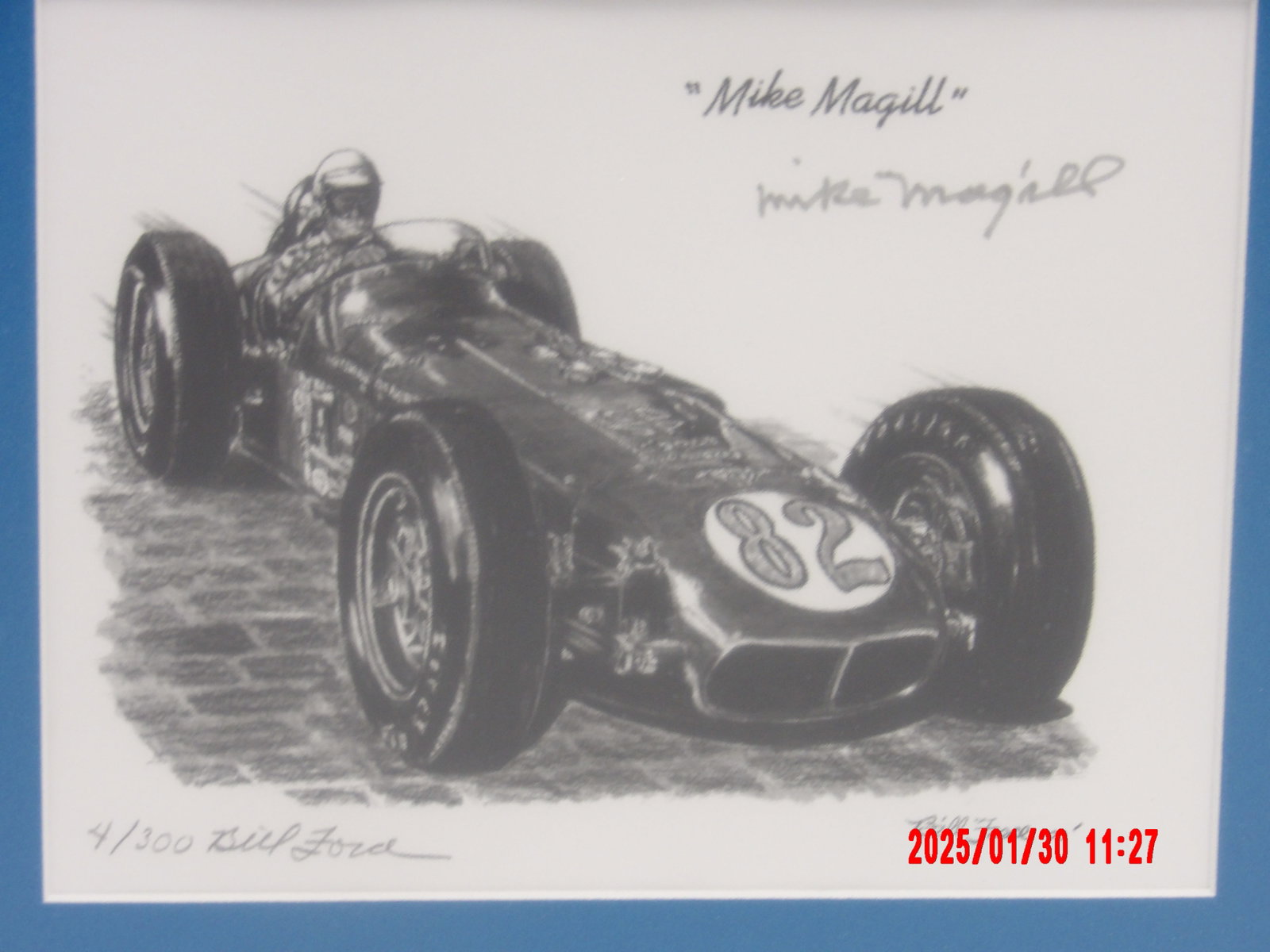 Framed Limited Edition Autograph "Mike Magill" Racing Caricature by Bill Force: This is a black and white pencil artwork featuring legendary race car driver Mike Magill in his classic #82 open-wheel race car. The car is depicted on a textured racing surface, likely a historic bri