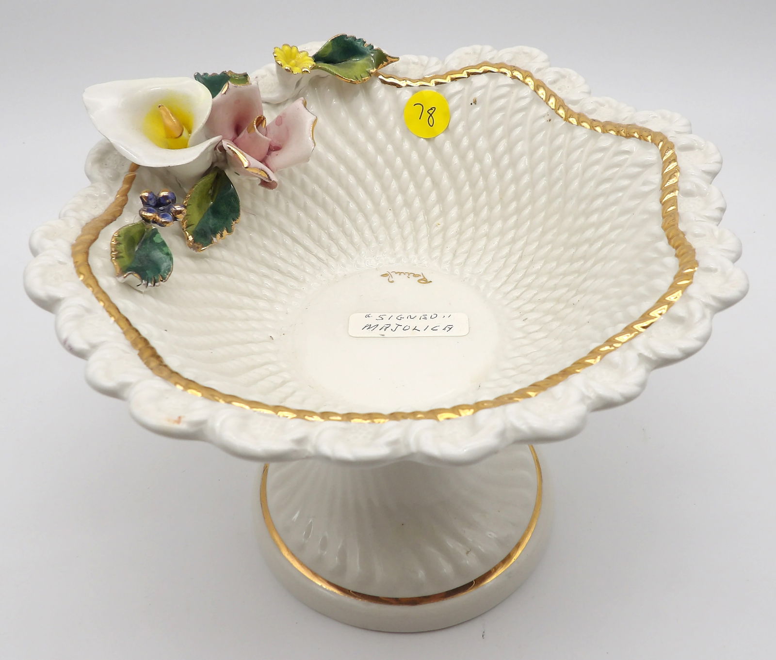 Italian Majolica Compote – Signed Pairi, Hand-Crafted Florals: This is a fine Italian Majolica pedestal compote, featuring a delicately woven basket-weave motif with scalloped edges, trimmed in hand-applied 24k-style gold gilt. The underside bears both a “Made