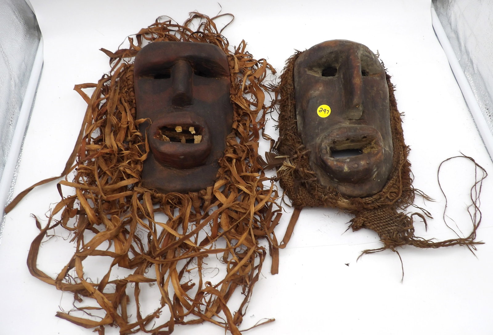 2 PC - WOODEN TRIBAL MASKS: These wooden masks are designed for ceremonial and decorative use, and have several symbolic elements (hair, features, and teeth) that tie in to their ceremonial use.