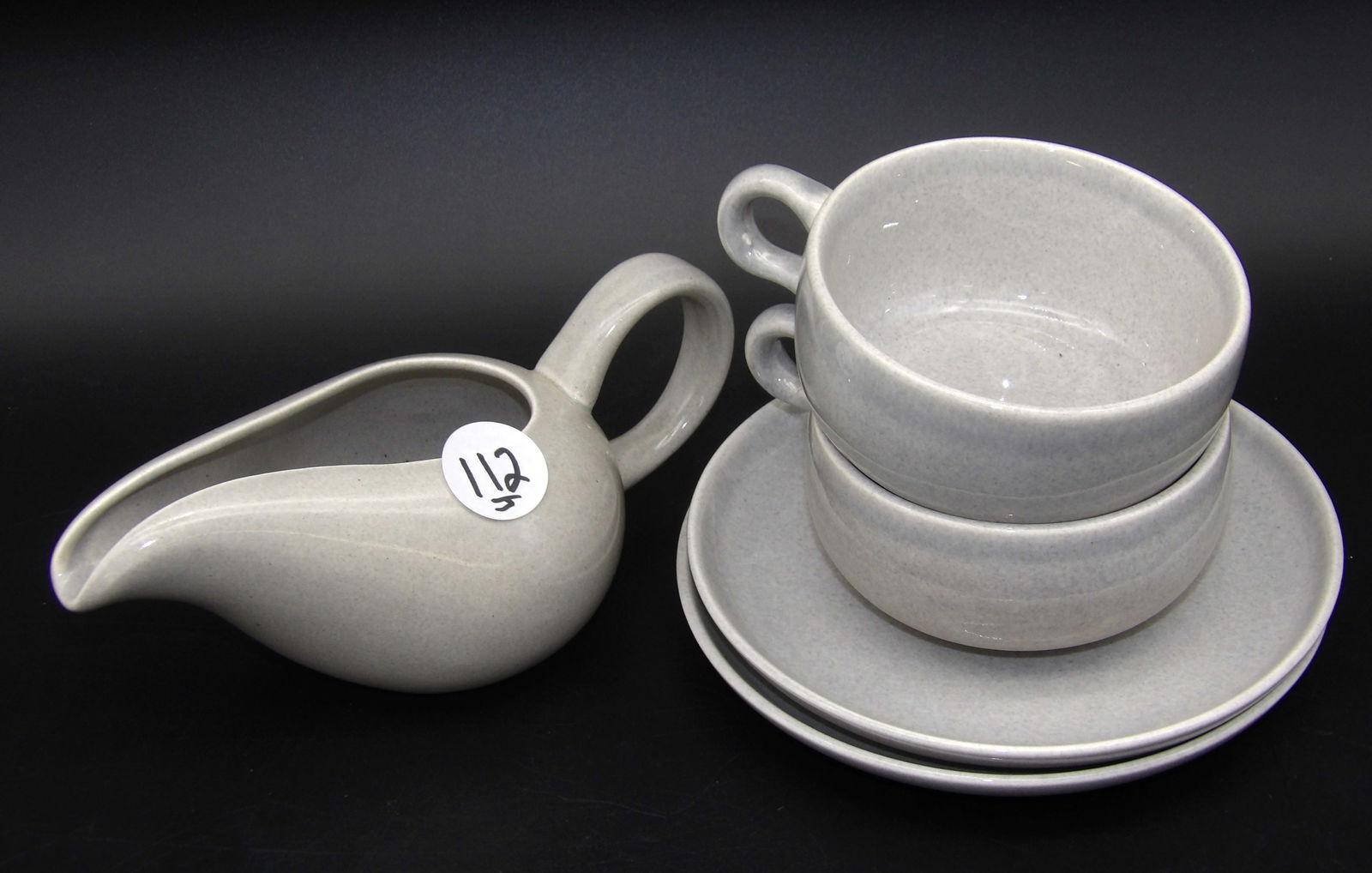 Russel Wright Creamer, Plates, Coffee Mugs (5 pcs): This lot of 5 lovely Russel Wright pieces includes a creamer, 2 plates, and 2 coffee mugs.Measures:3" x 3.5" x 7", 2" x 5" x 4", 6"