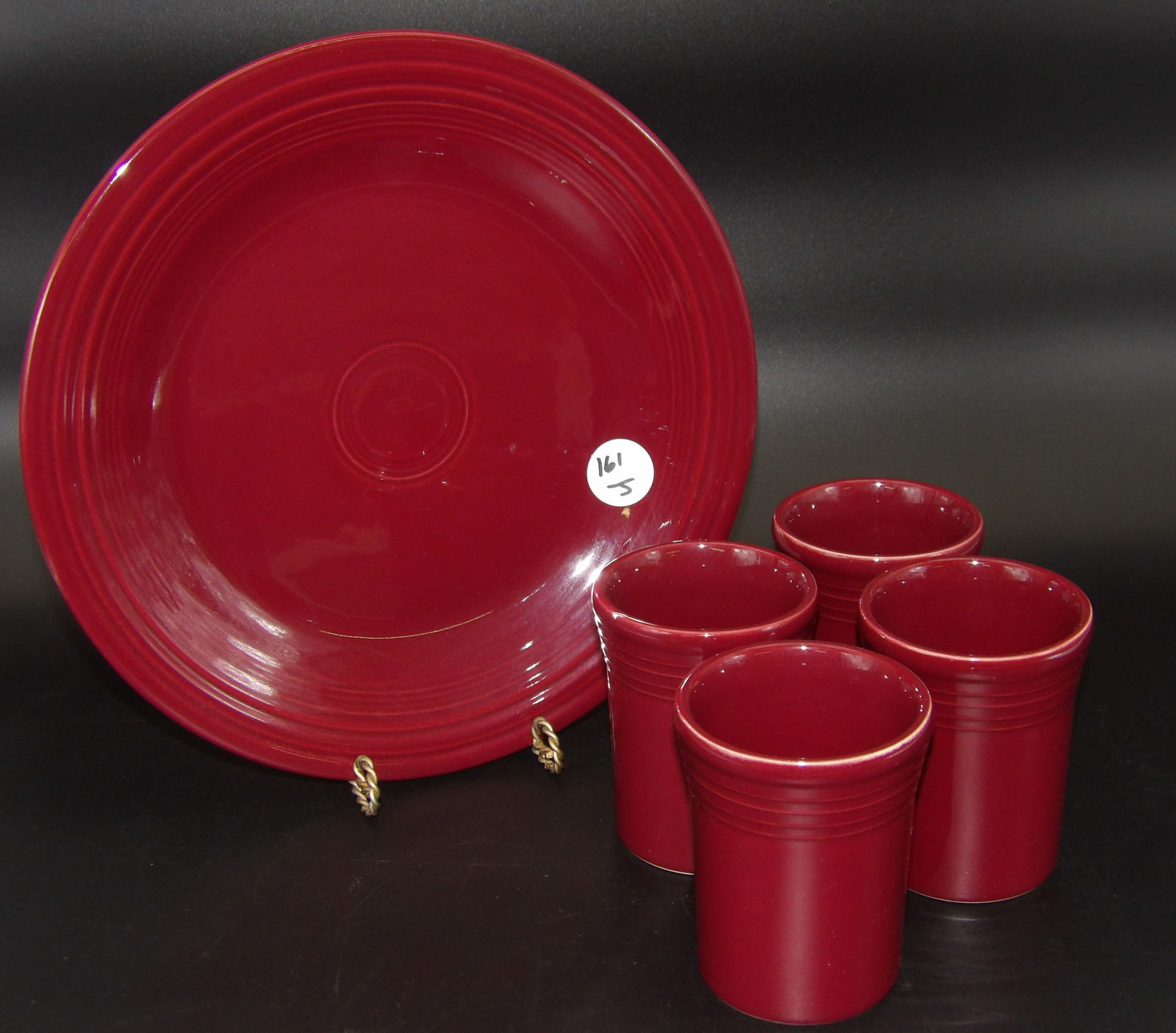 Fiestaware Dinner Plate & 4 Tumbler Cups: This Fiestaware lot features a dinner plate and 4 tumbler cups, all in a Burgundy glaze.Measures:10.5", 4" x 3"