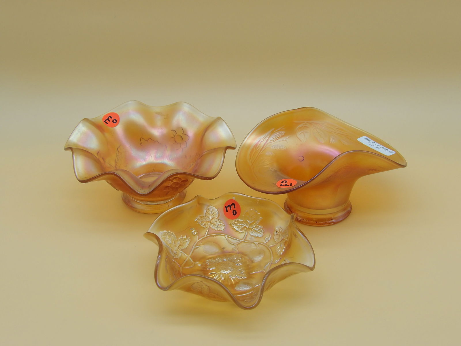 Dugan Marigold Ruffled Bowl, Fenton Marigold Strawberry Bowl, Fenton Marigold "Hat" Holly Bowl: This lovely glassware trio includes a Dugan Marigold Ruffled Bowl (3" x 7"), Fenton Marigold Strawberry Bowl (2" x 6"), and a Fenton Marigold "Hat" Holly Bowl (3.6" x 6.5" x 5"). Early 20th Century