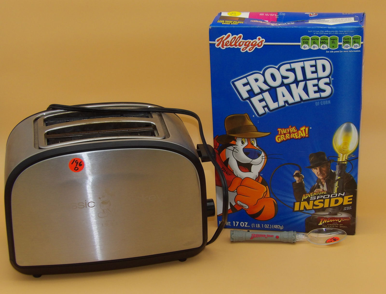 Disney 'Classic Mickey' Toaster & Indiana Jones Frosted Flakes Box w/ Adventure Spoon: This lot includes a 'Classic Mickey' Disney toaster, which puts the image of Mickey onto the toast. Also included is a Frosted Flakes box featuring Indiana Jones and including a special 'Adventure