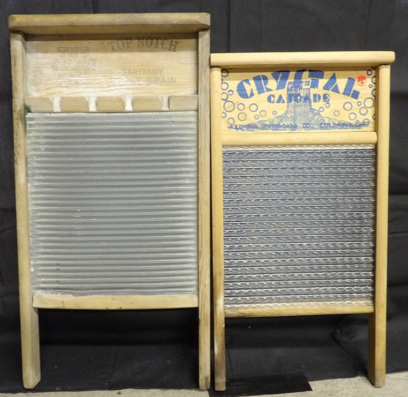 National & Columbus Washboards (2 pcs): This pair of vintaeg washboards includes a Columbus Washboard Co. ribbed glass 'Crystal Cascade' washboard, and a National Washboard Co. ribbed metal 'Celery City / Top Notch' washboard. Measures 24"