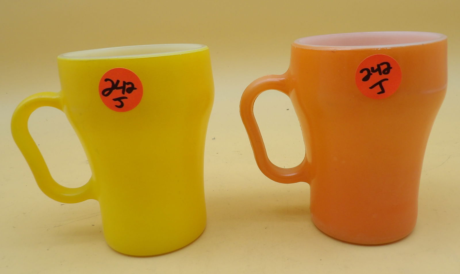 Fire King Anchor Hocking Soda Mugs (2): This pair of Anchor Hocking Fire King soda mugs comes in yellow & orange. 1950's / 60's. Measures 4" each.