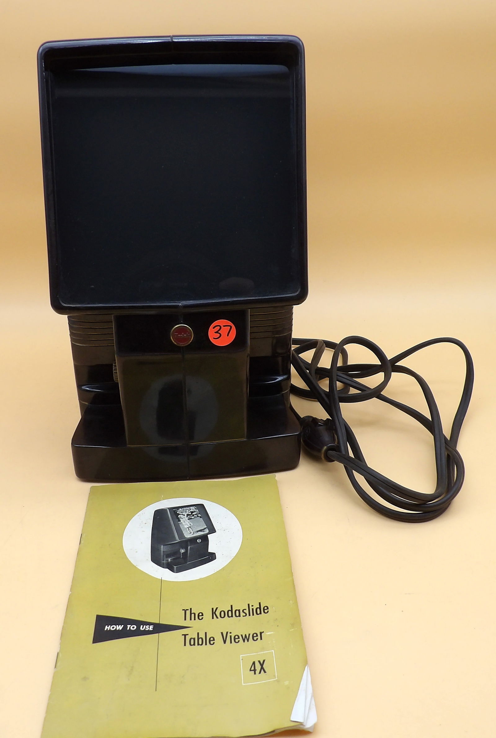 Kodak Kodaslide Table Slide Viewer: This vintage 1950's Kodak Kodaslide Table Viewer features a lamp and magnified viewing screen to view slides. Includes original instruction booklet. Works, but lamp is weak - bulb may need to be