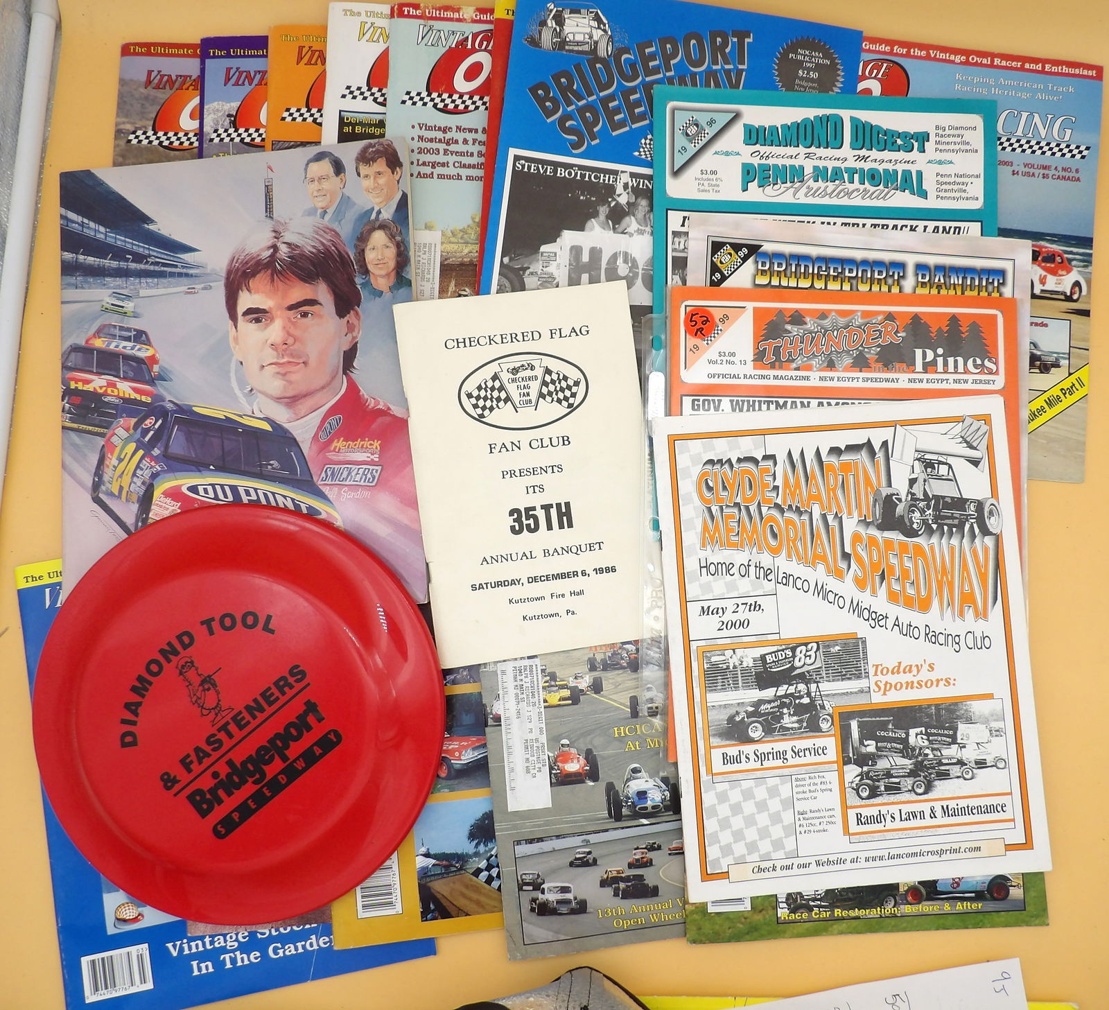 Vintage Speedway Racing Magazines / Programs and Frisbee (22 pcs): This 22-piece collection of vintage racing magazines / programs includes 14 issues of Vintage Oval Racing (early 2000's), as well as issues of Diamond Digest, Bridgeport Bandit, Bridgeport Speedway