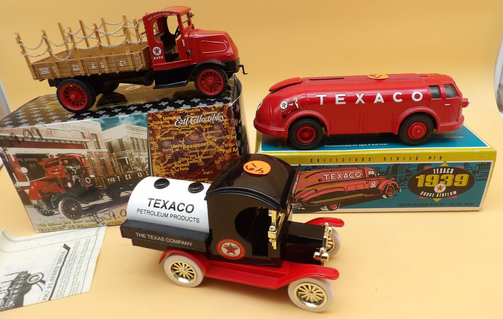 Texaco Die Cast Truck Banks (4): This group of 4 die cast Texaco truck banks includes a 1939 Dodge Airflow, a 1934 Dimaond T Doodle Bug, a 1912 Ford Model T Delivery Truck (missing steering wheel), and a 1918 Mack AC Bulldog Flat