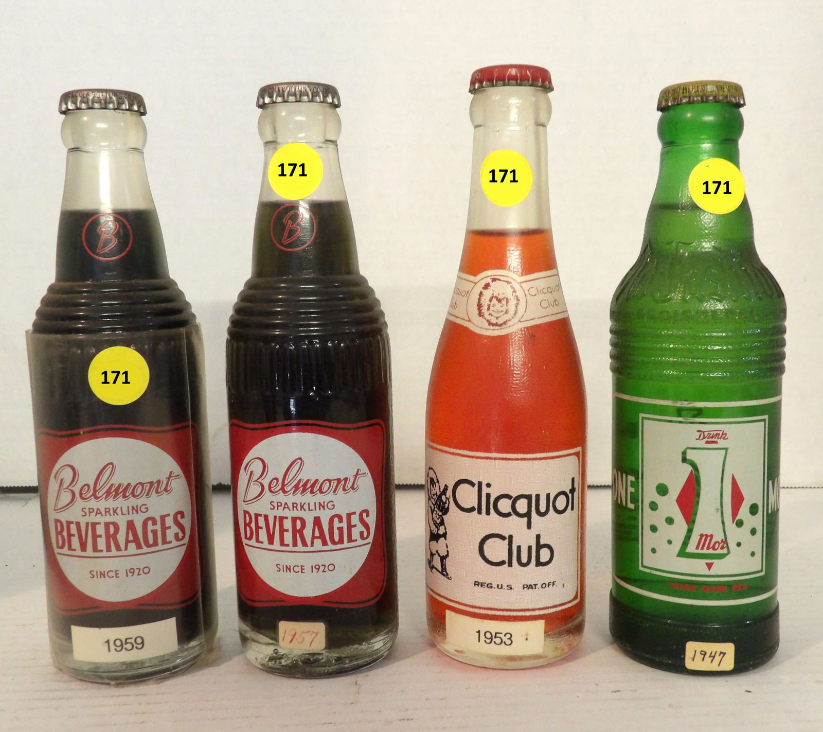 Clicquot Club Strawberry Cream Soda, One Mor Bitter Lemon Soda, Belmont Grape Glass Bottles (4 pcs): This group of vintage glass bottles includes a 1953 Cliquot Club Strawberry Cream Soda (sealed w/ original contents), a 1947 One Mor Bitter Lemon Soda (sealed w/ original contents), a 1957 Belmont Spa