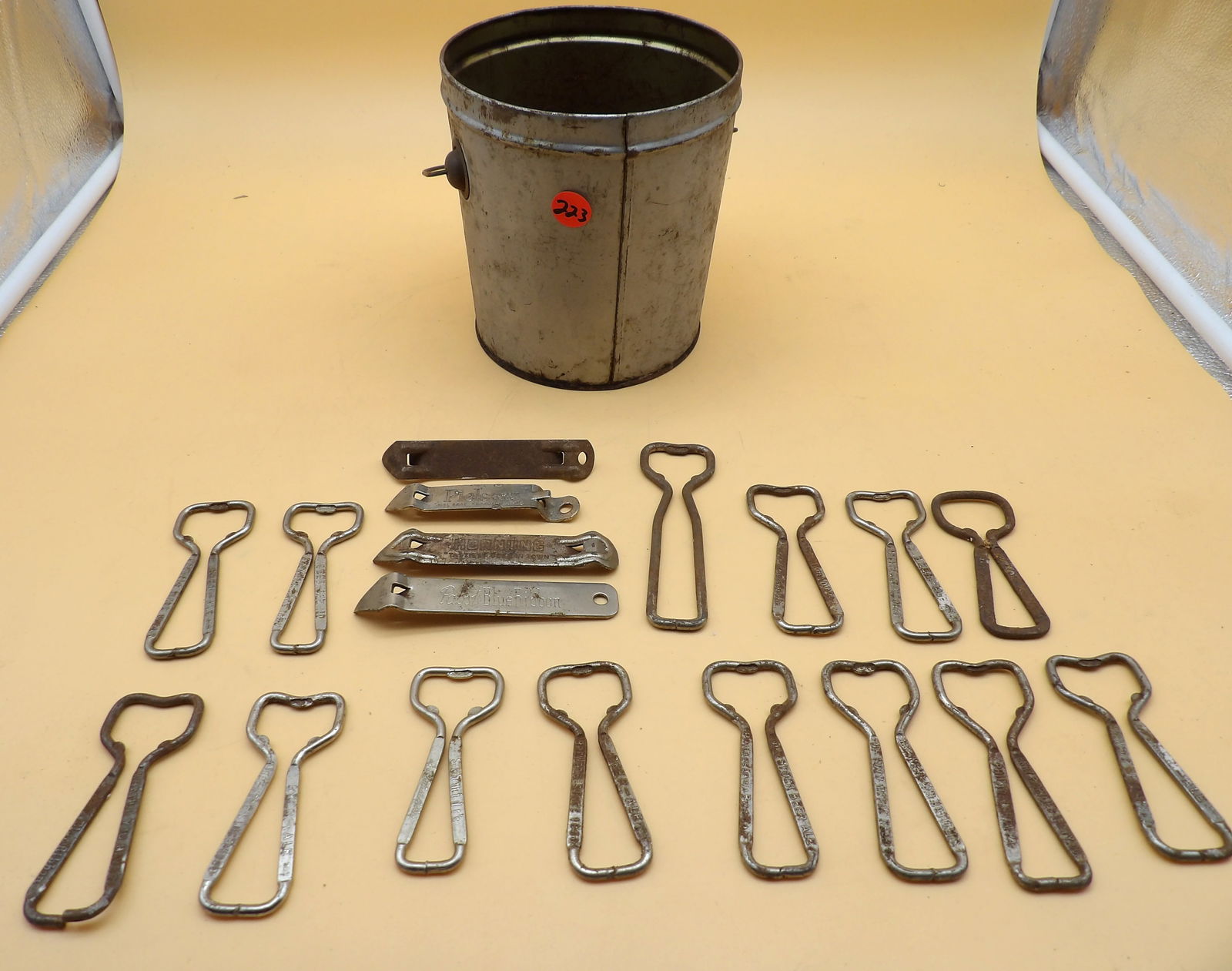 Vintage Beer Bottle / Can Openers (18): This lot of 18 vintage bottle / can openers features brands like Schmidt's, Old-Stock, Pabst Blue Ribbon, Piel's, and Hornung and comes in a metal bucket.